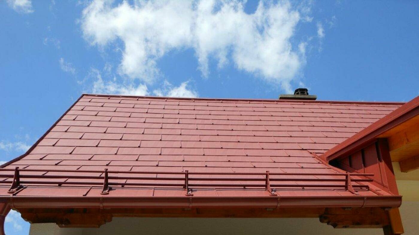 Detailweergave van een dakvlak met het PREFA dakpaneel FX.12 in oxiderood met sneeuwvangsysteem.