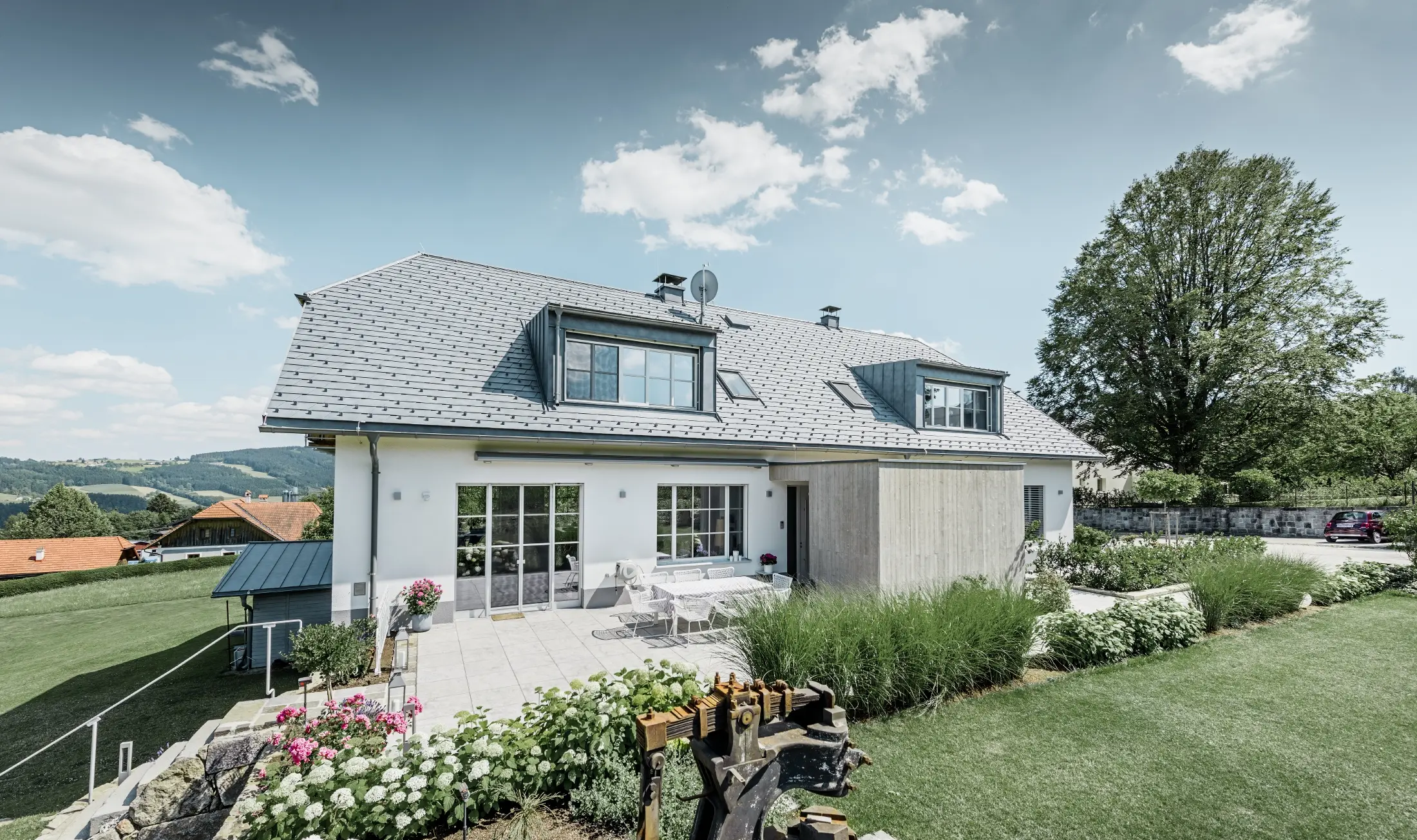 Klassieke eengezinswoning met schilddak met wolfseinden, dakrenovatie met PREFA dakschindels in steengrijs met mooi aangelegde tuin en ruim terras.