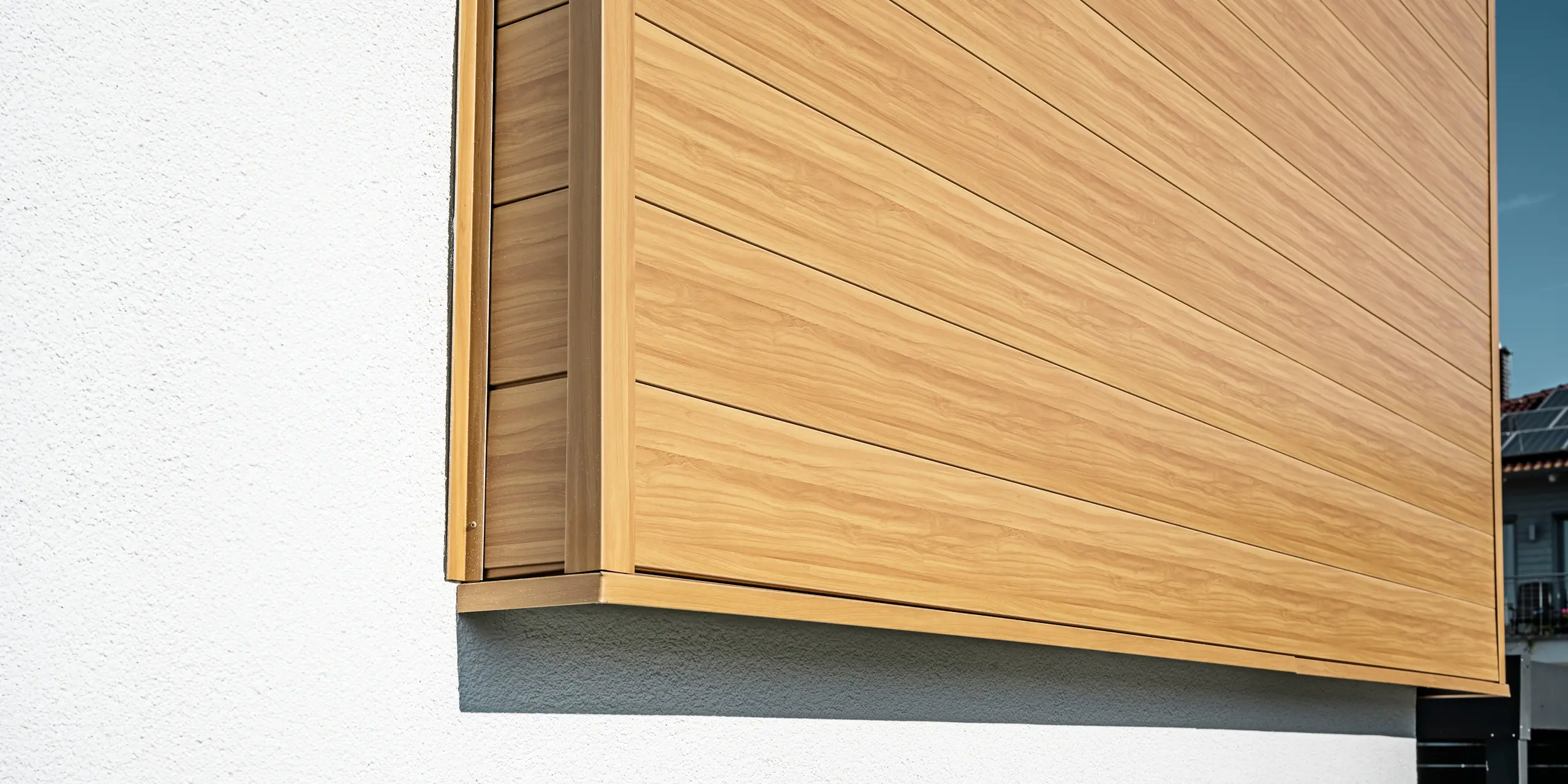 Close-up van de aluminium gevelbekleding van PREFA Siding in de kleur eiken naturel aan een eengezinswoning in Usingen, Duitsland.