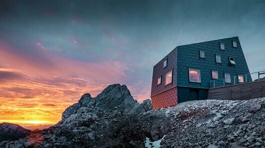 Buitengewone architectuur in de bergen: de Seethalerhütte op de Dachstein bekleed met PREFA dak- en gevelpaneel FX.12 in steengrijs.