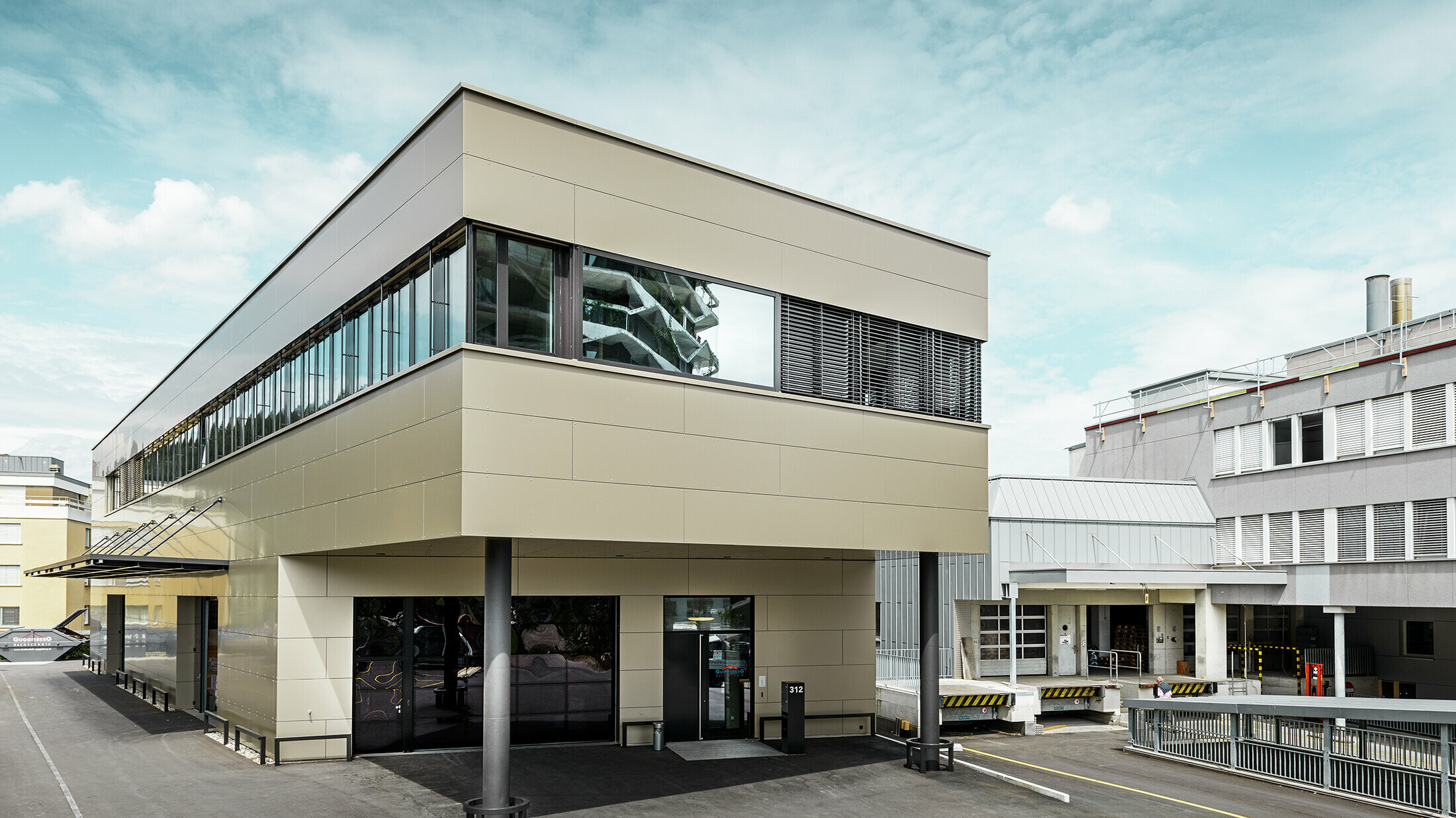 Moderne aanbouw met werkplaats en bureau afgewerkt met bronskleurige aluminium composietplaten van PREFA