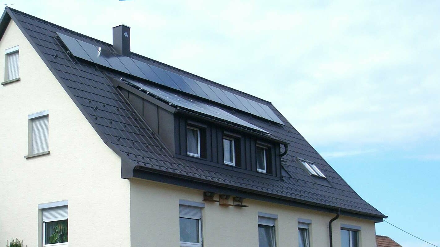 Nieuw gerenoveerd dak met de PREFA dakplaat in antraciet, de koekkoek werd bekleed met Prefalz; op het dak bevindt zich een fotovoltaïsche installatie.