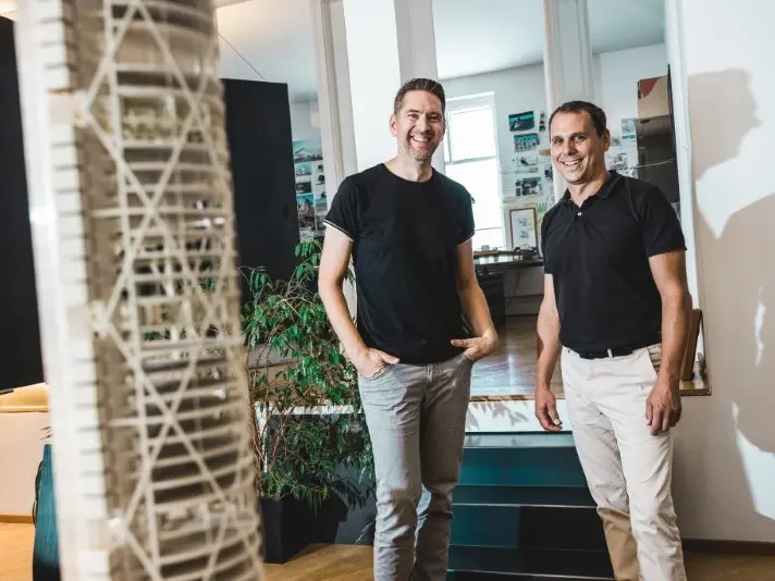 Die Architekten Christian Formann und Stefan Puschmann von f²p architekten lächeln in die Kamera.