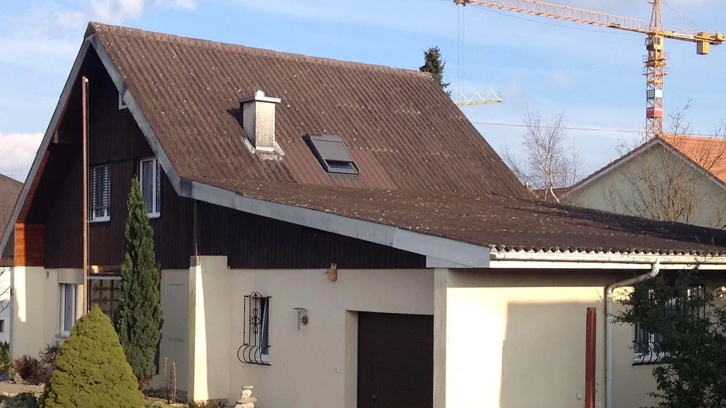 Huis voor de dakrenovatie met PREFA dakplaat, zadeldak en garage