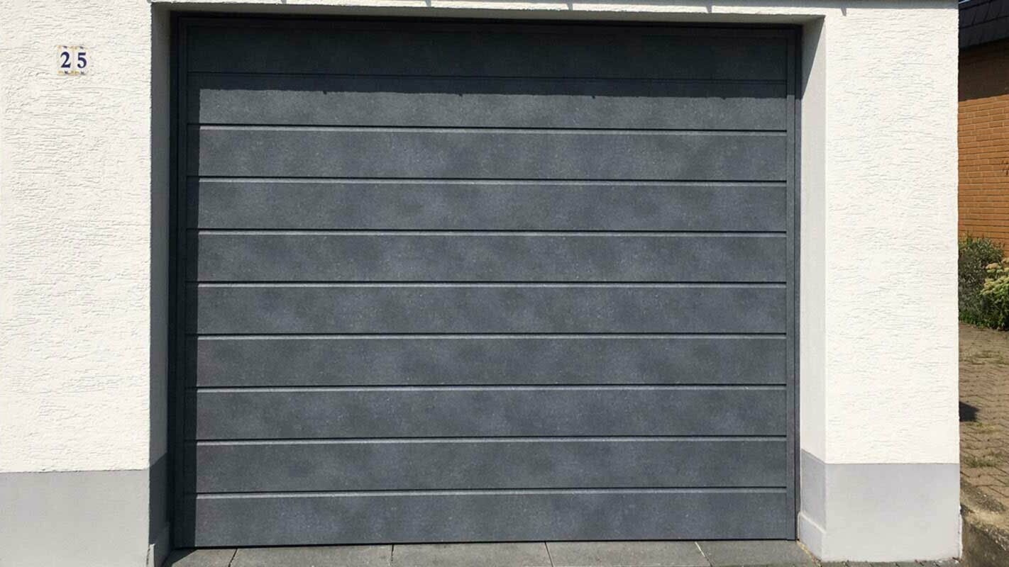 Garagepoort bekleed met horizontaal gelegde gevelbeplating in steengrijs van PREFA