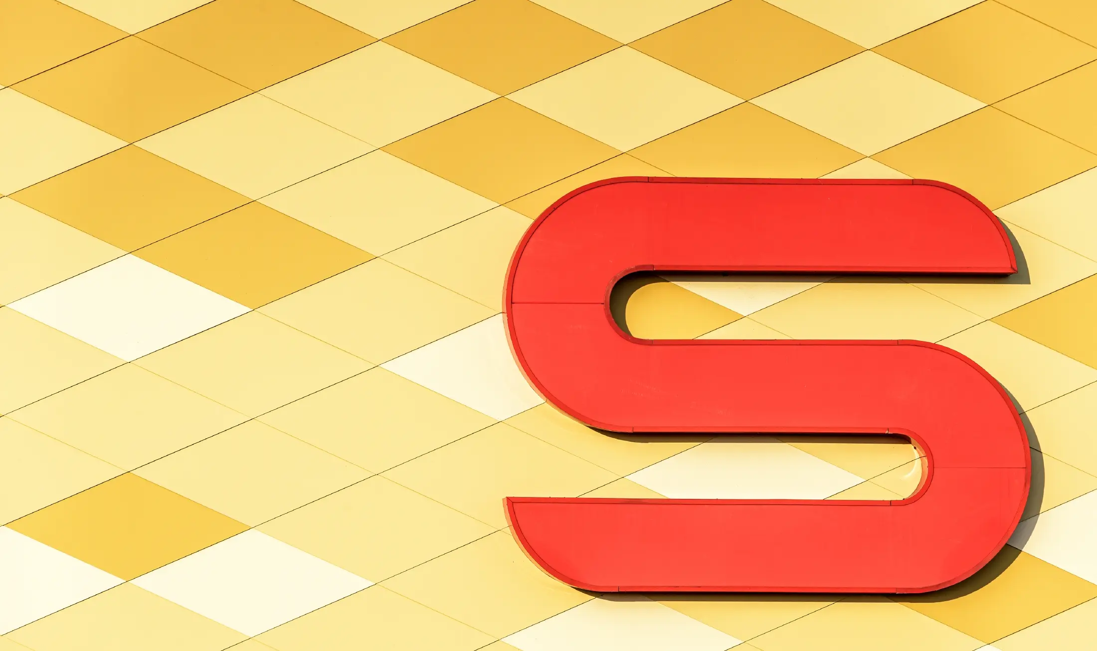 Spar-supermarkt met aluminiumgevel in ruitvormige, geel-oranje composietplaten en Spar-logo