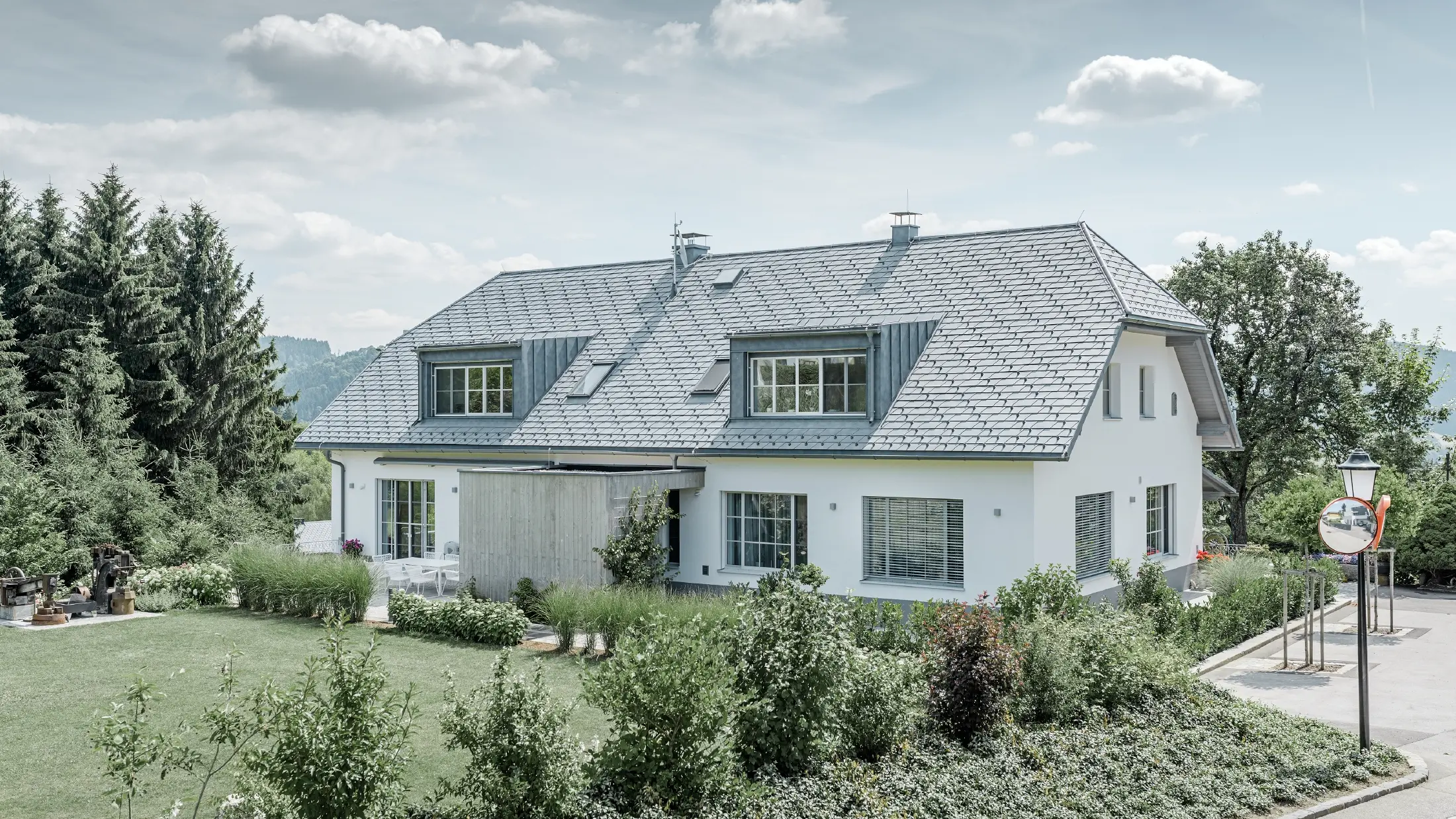 Dakrenovatie van een schilddak met de lichte PREFA dakschindel in steengrijs met twee dakkapellen.