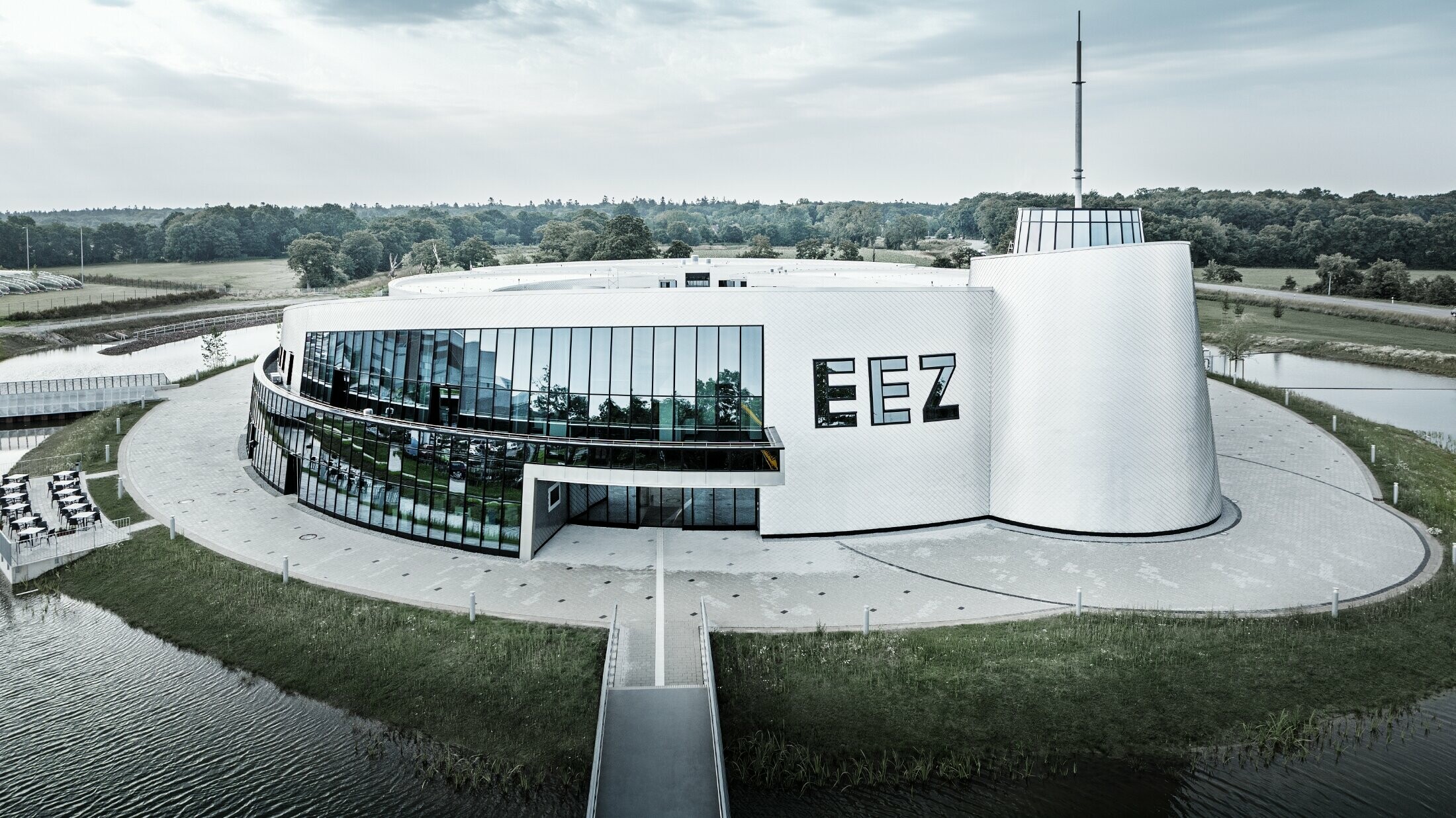De vele ronde bouwdelen van het Energie-Erlebnis-Zentrum Aurich (EEZ) werden bekleed met PREFA gevellosange 20 × 20 in blank naturel.
