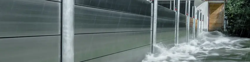 Close-up van de PREFA-hoogwaterbescherming van aluminium, die altijd bestand is tegen overstromingsrampen en het vrijstaande huis op de achtergrond beschermt.