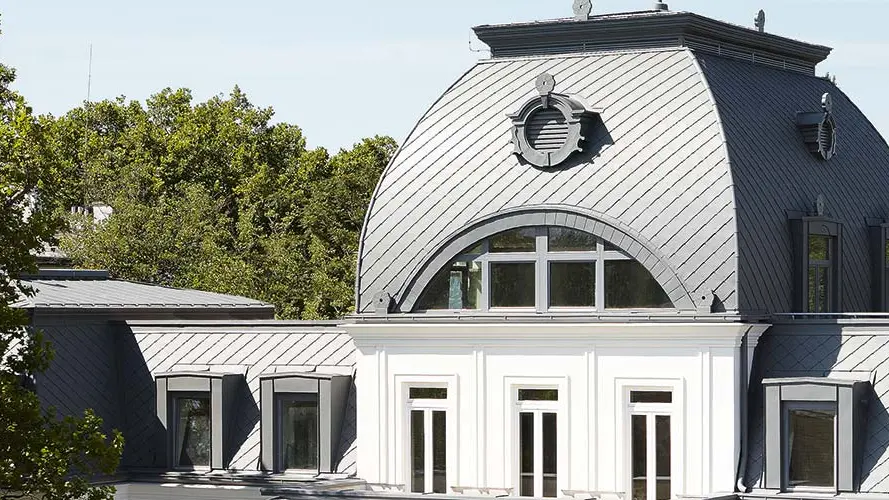 Mansardedak met koepel van het beschermde gebouw gerenoveerd met PREFA daklosanges en Prefalz in P.10 lichtgrijs
