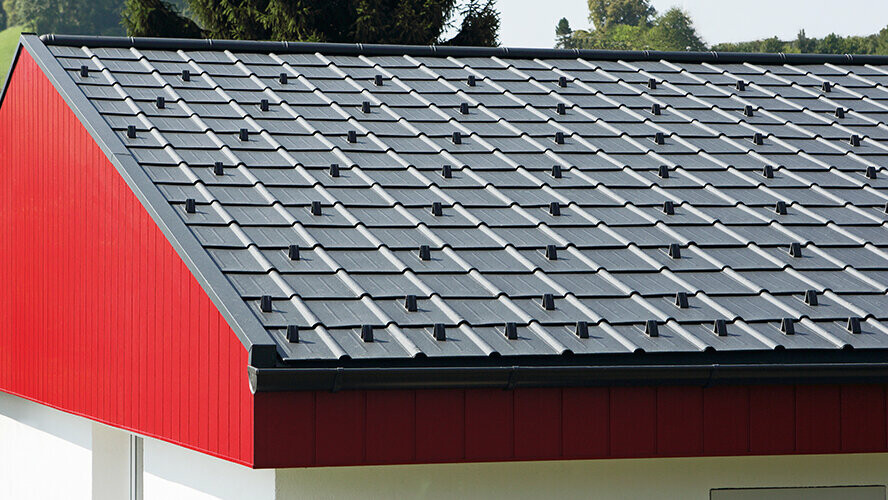 Bekleding van een puntgevel in rood met aluminium PREFA Siding, verticaal gelegd. Op het dak werd het PREFA-dakpaneel gelegd in P.10 antraciet.