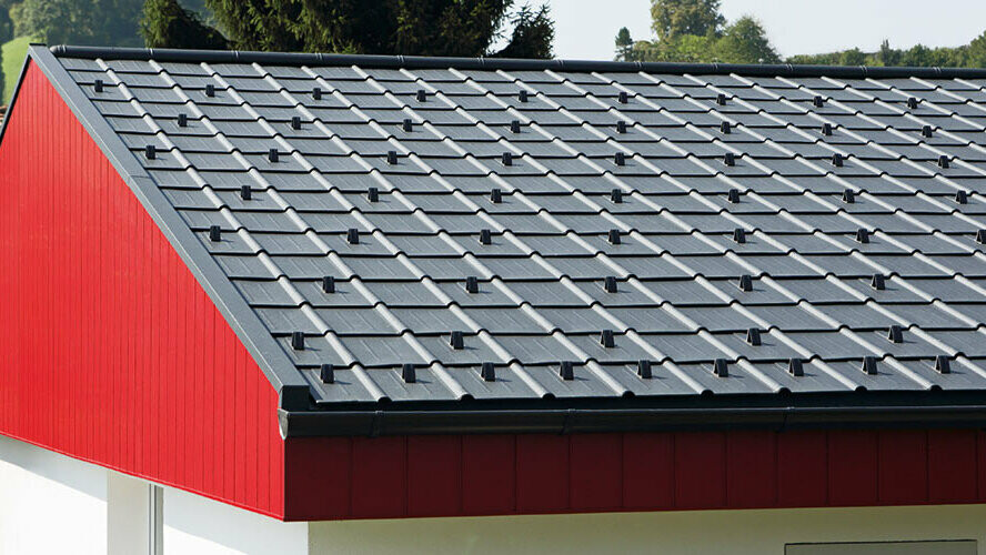 Bekleding van een puntgevel in rood met aluminium PREFA Siding, verticaal gelegd. Op het dak werd het PREFA-dakpaneel gelegd in P.10 antraciet.