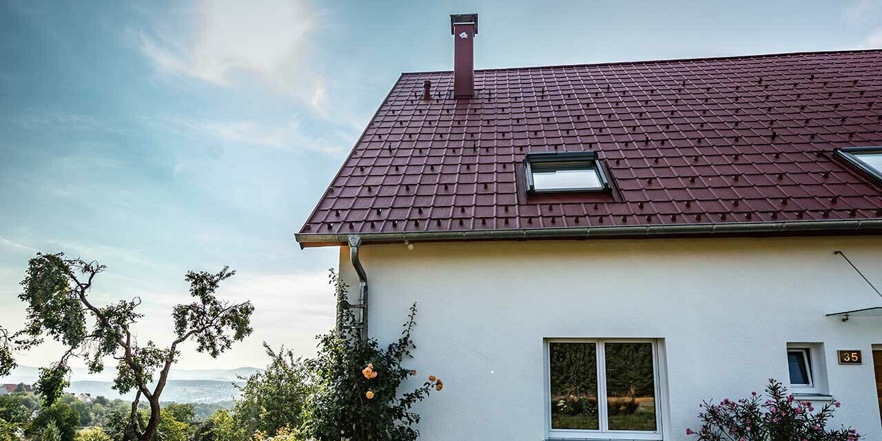 Huisje op het land, nieuw gerenoveerd dak met PREFA dakpan in oxiderood, omsluiting van dakraam en schoorsteen.