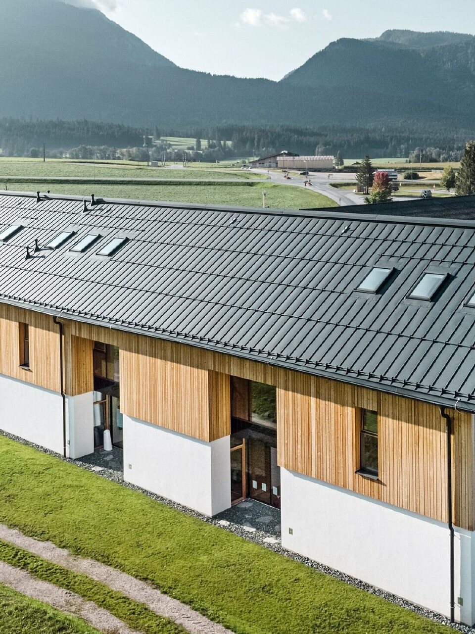 Kruidenkleuterschool in Bad Mitterndorf met groot PREFALZ dak in P.10 antraciet en houten gevel