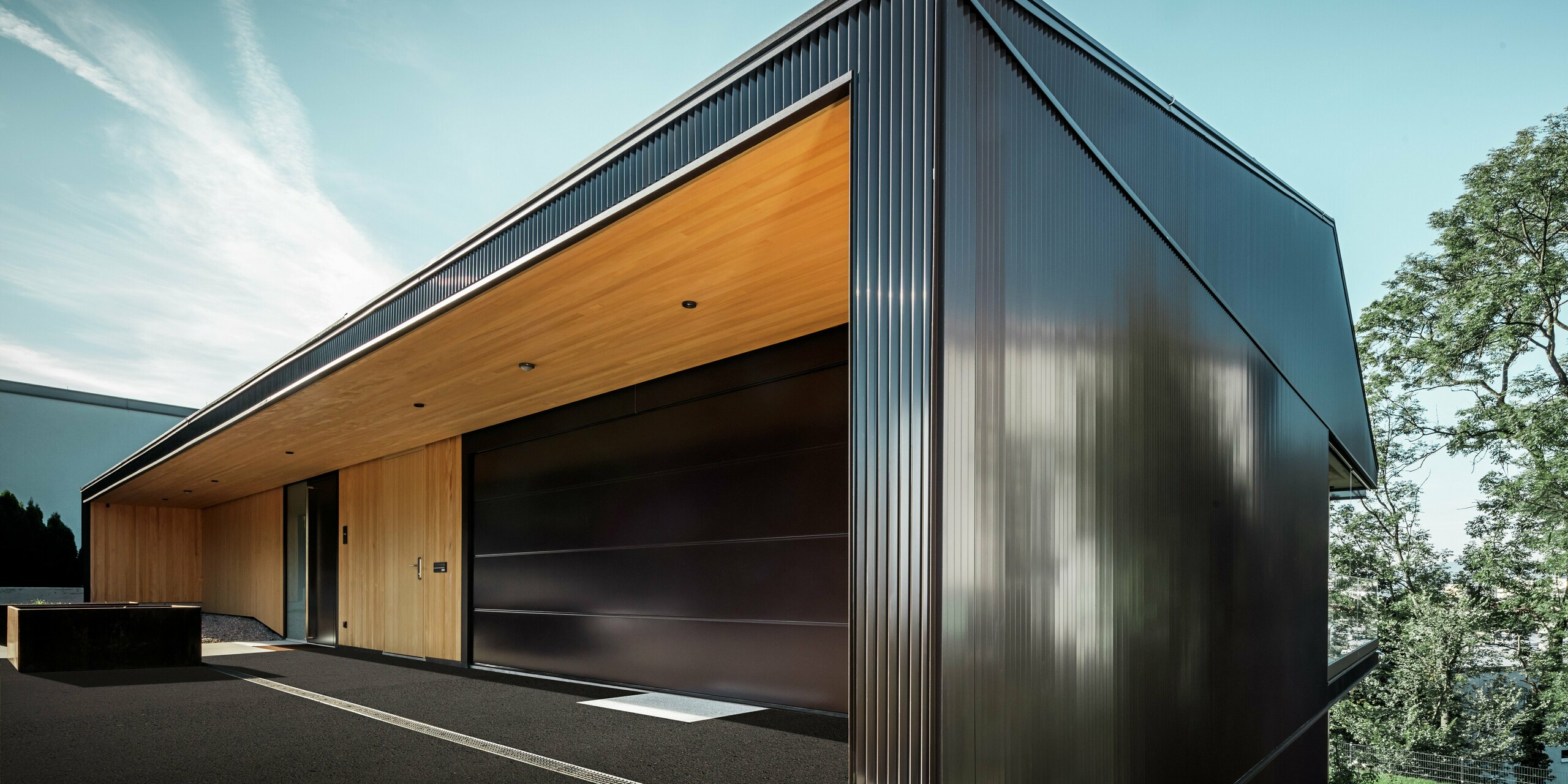Garage-ingang van een eengezinswoning, de gevel is bekleed met het PREFA kartelprofiel in donkerbruin.