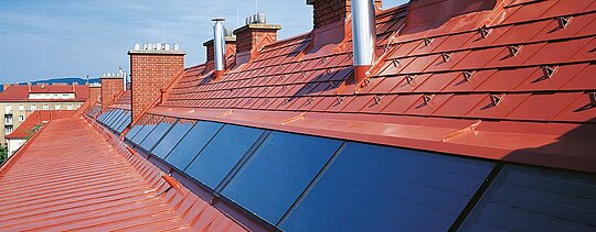 Detailfoto van de baksteenrode PREFA-dakschindel inclusief sneeuwstoppers bij Hugo Breitner Hof.