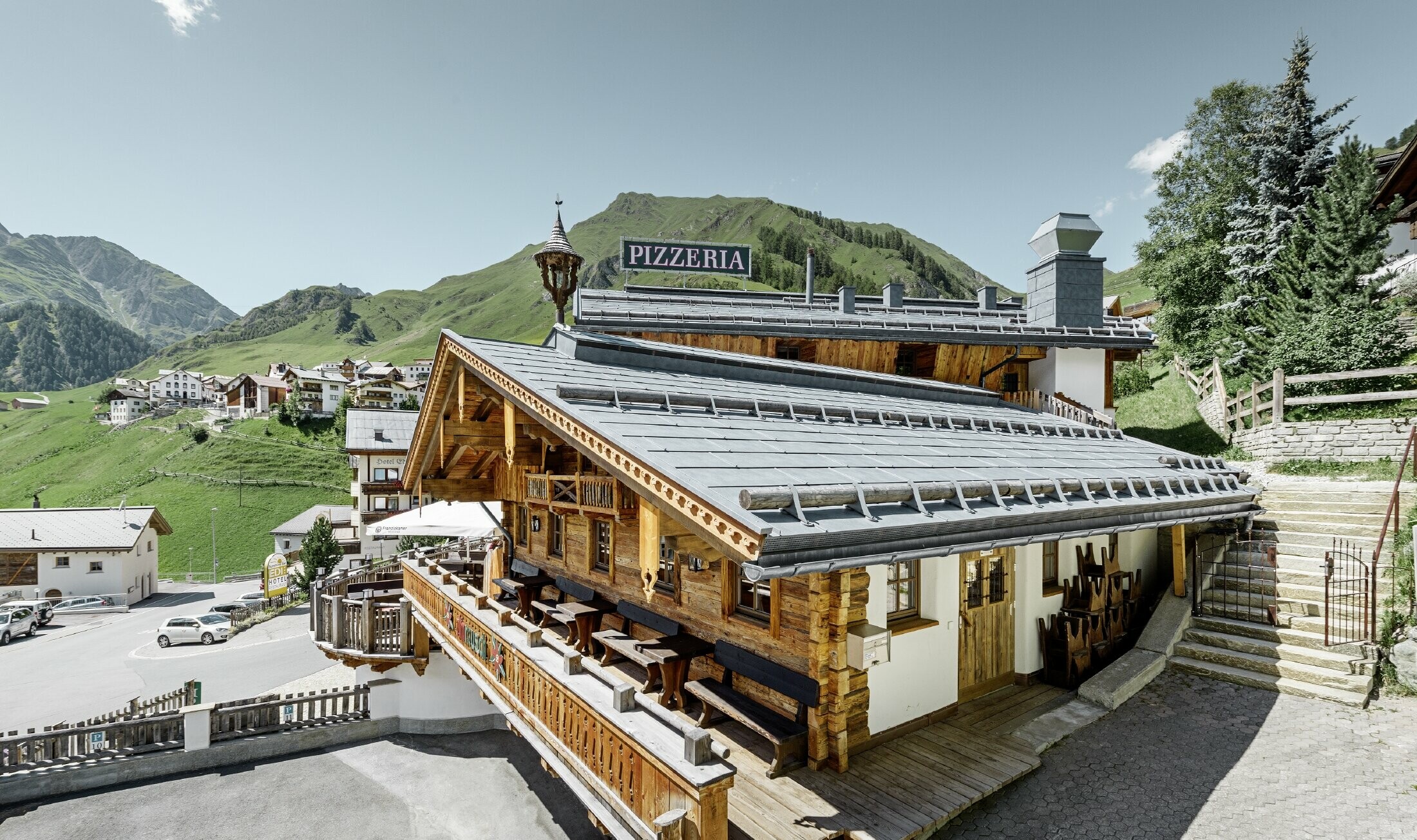 Restaurant Almrausch in bergdecor met FX.12 dakpanelen in steengrijs en sneeuwvangers op het dak