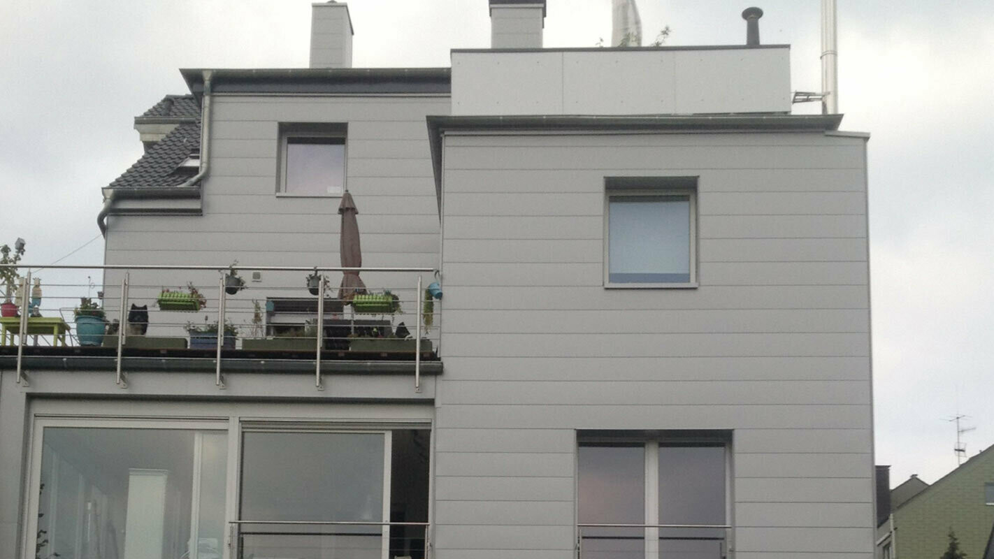 Wooncomplex met plat dak en terras met nieuw gerenoveerde gevel met de PREFA gevelbeplating