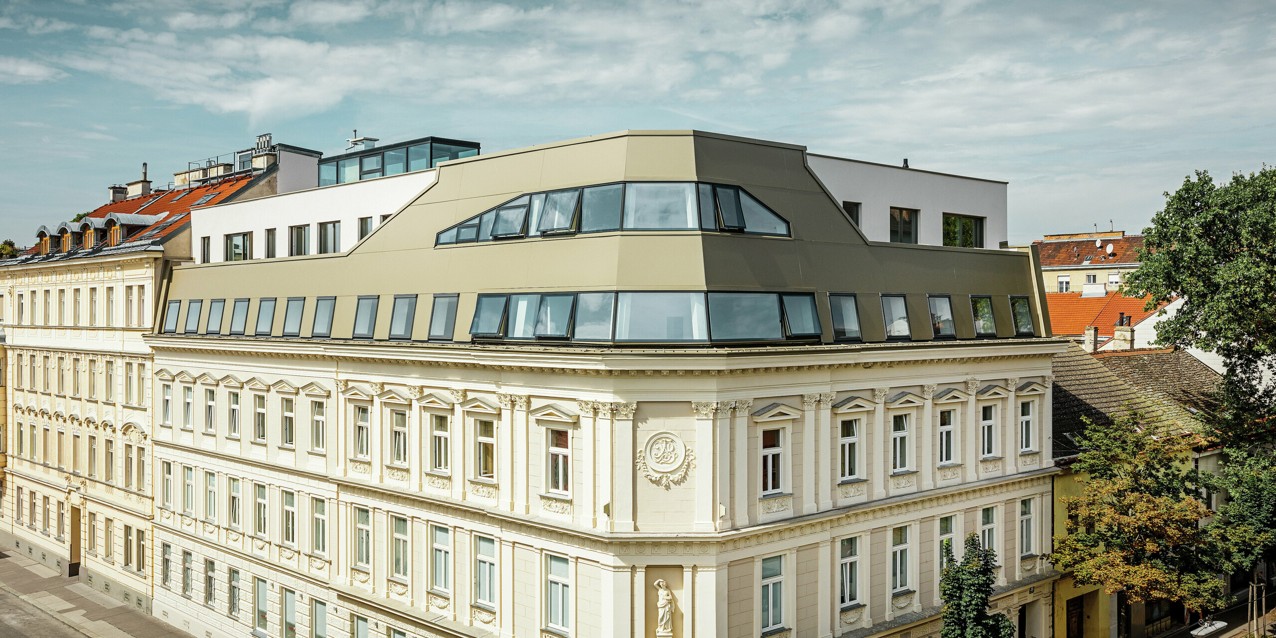 Dakuitbreiding in de Schloßhofer Straße in Wenen met bronskleurige aluminium composietplaten van PREFA