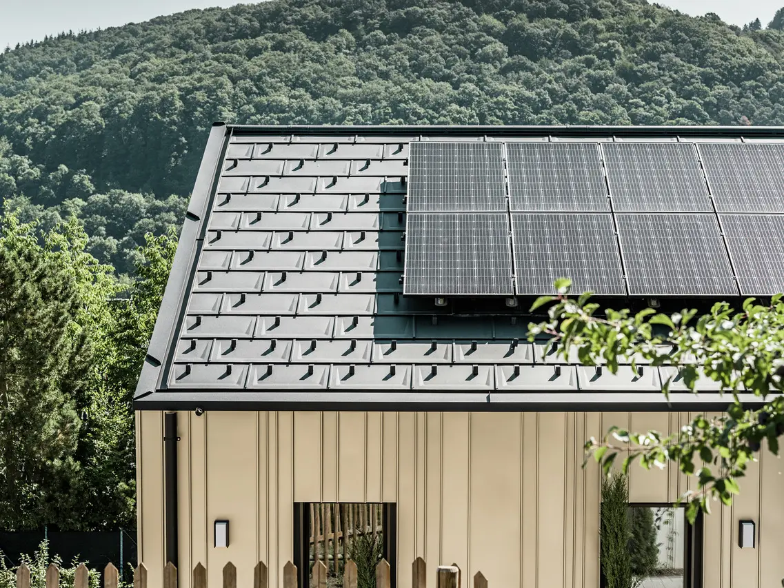 Blik op een eengezinswoning bedekt met de DS.19 met het PREFA montagesysteem voor zonnepanelen.