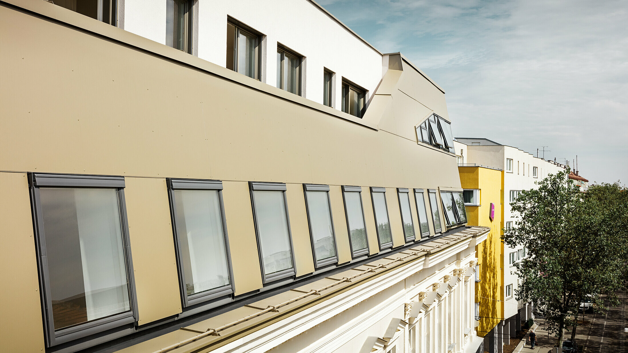 Dakuitbreiding in de Schloßhofer Straße in Wenen met bronskleurige aluminium composietplaten van PREFA