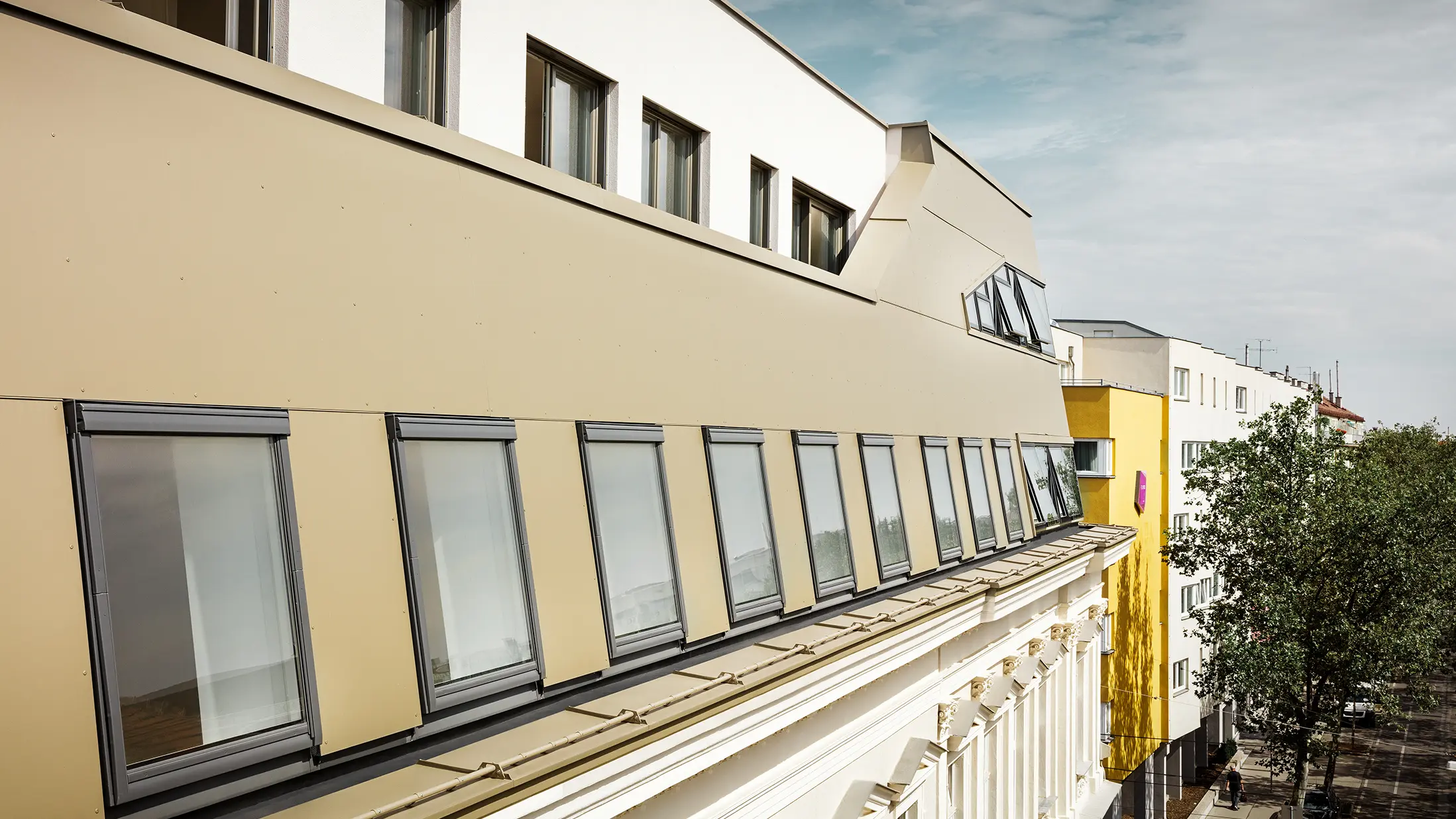 Dakuitbreiding in de Schloßhofer Straße in Wenen met bronskleurige aluminium composietplaten van PREFA