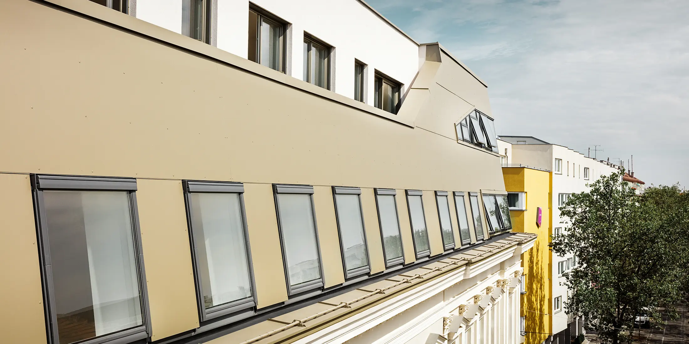 Dakuitbreiding in de Schloßhofer Straße in Wenen met bronskleurige aluminium composietplaten van PREFA