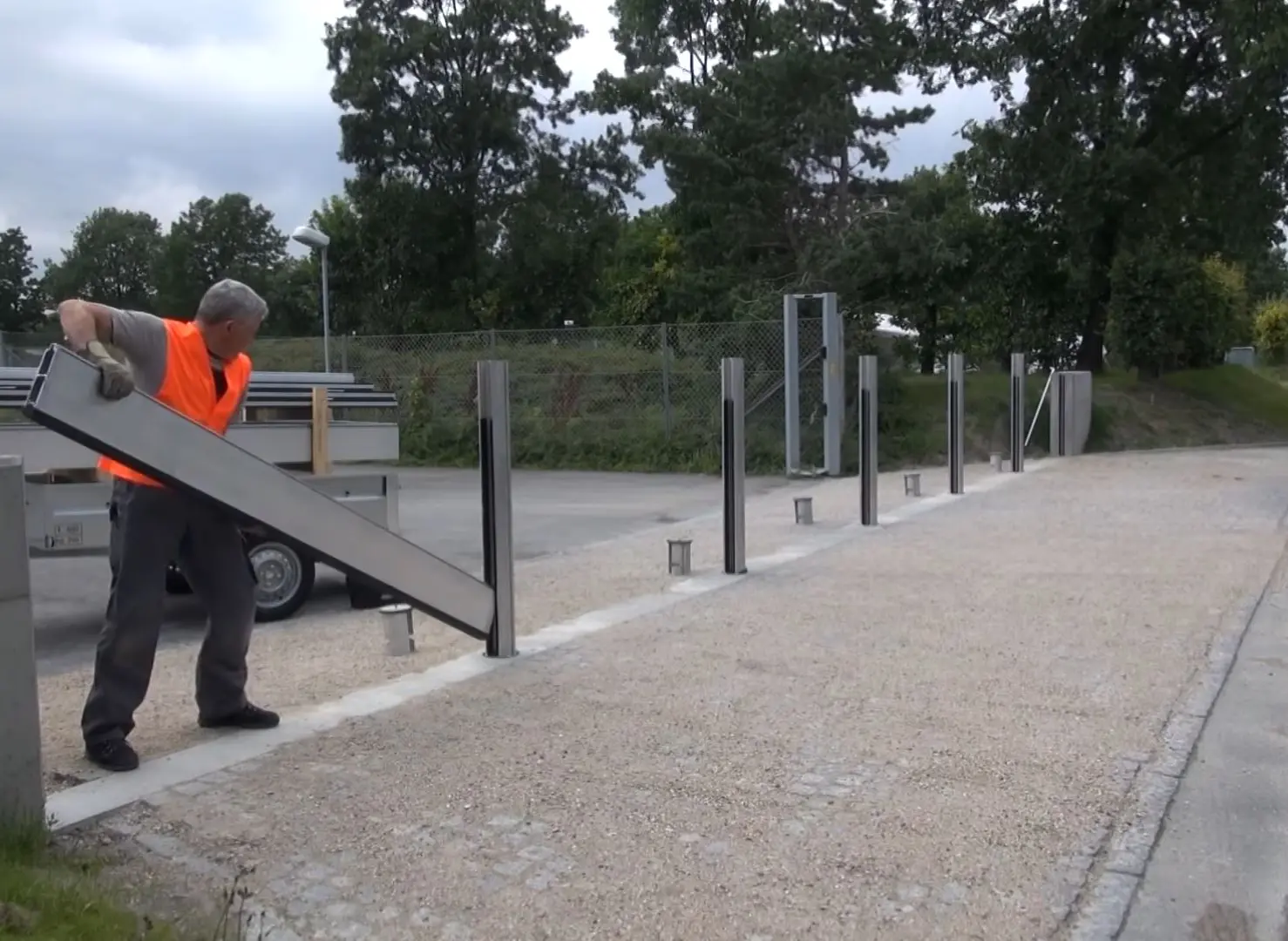 Een man installeert het PREFA-hoogwaterbeschermingssysteem. 