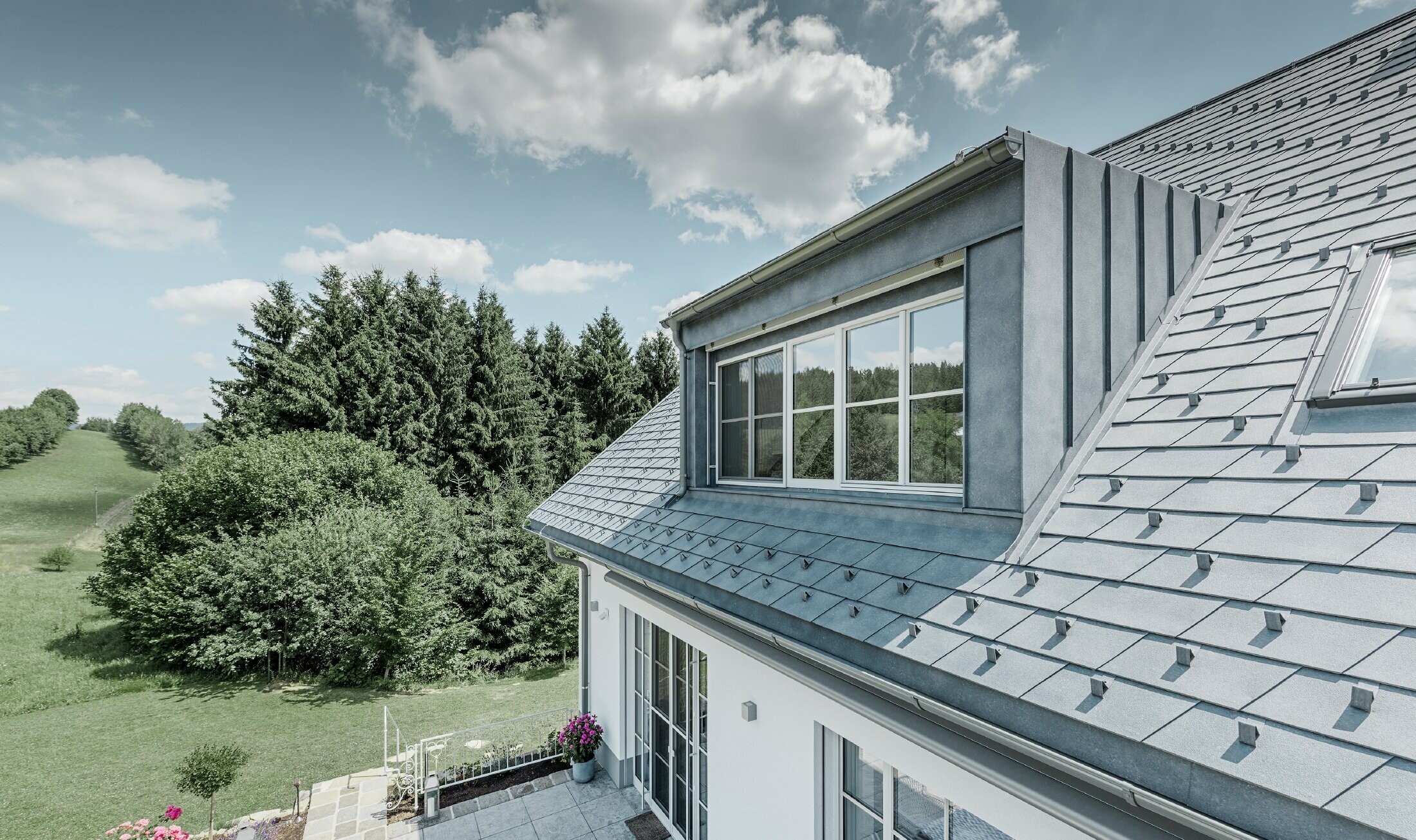 Dakkapel van de nieuw gerenoveerde eengezinswoning met de PREFA dakschindel in steengrijs. De dakkapel is bekleed met Prefalz (staande fels).