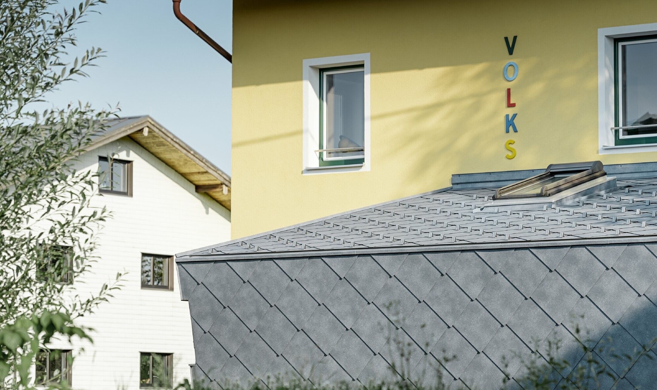 Aanbouw van een lagere school met aluminium dak- en gevellosanges van PREFA in steengrijs