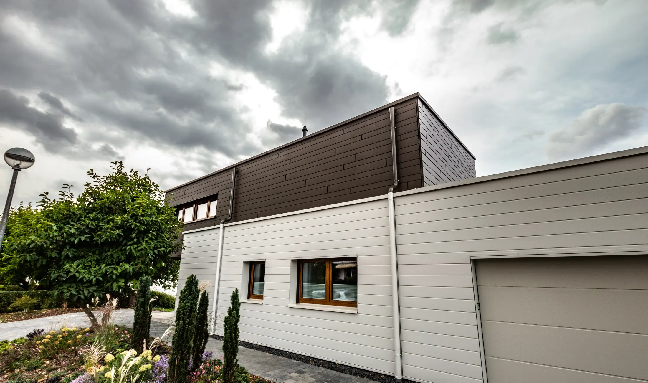 Gevelbekleding van een garage met de PREFA sidings horizontaal in wit, met spuwermond.