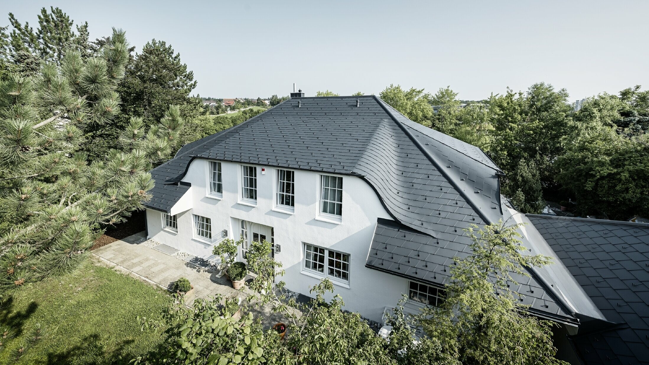 Schilddak met veel gebogen dakkapellen, bekleed met aluminium dakschindel DS.19 in antraciet