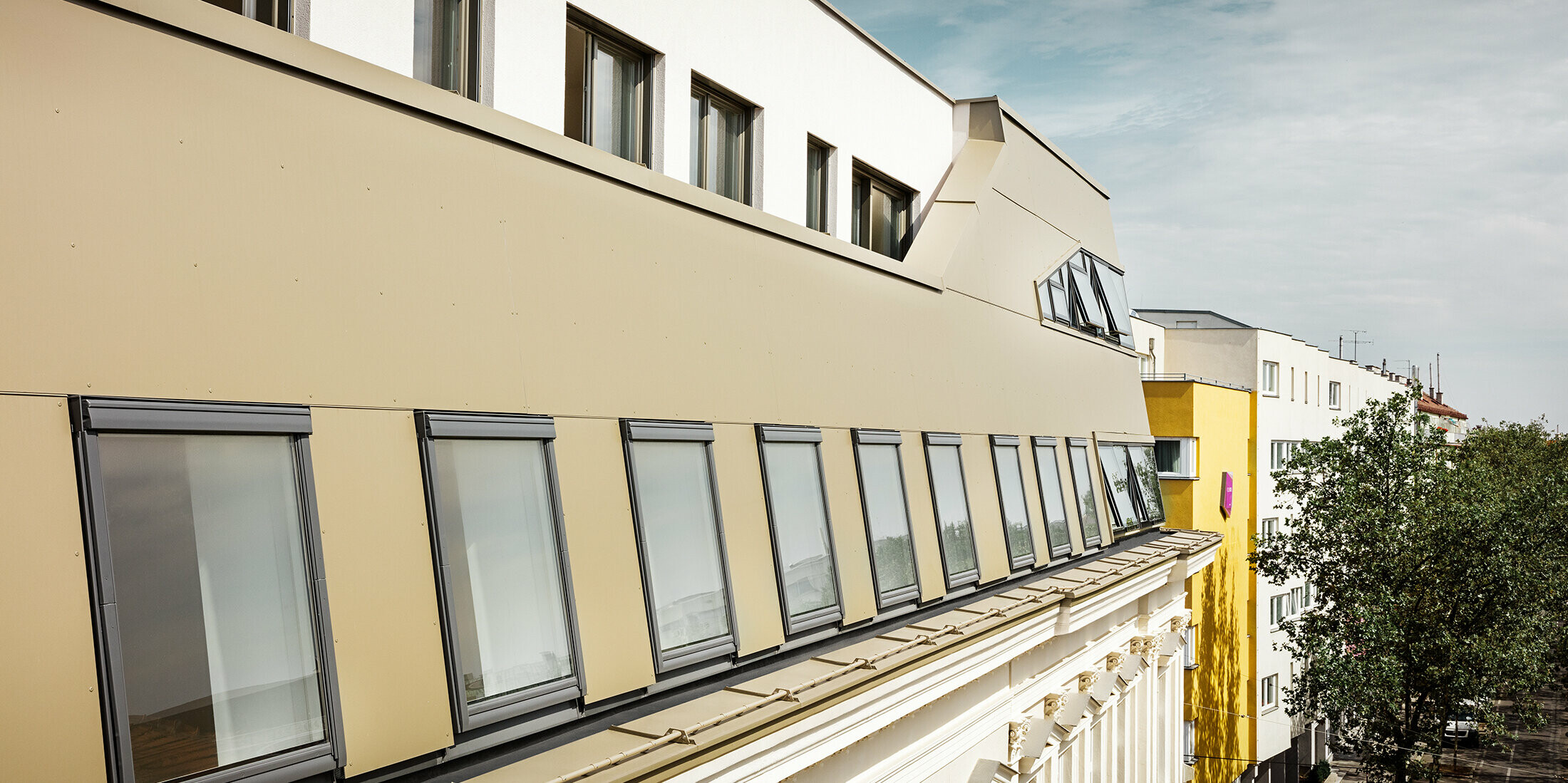 Dakuitbreiding in de Schloßhofer Straße in Wenen met bronskleurige aluminium composietplaten van PREFA