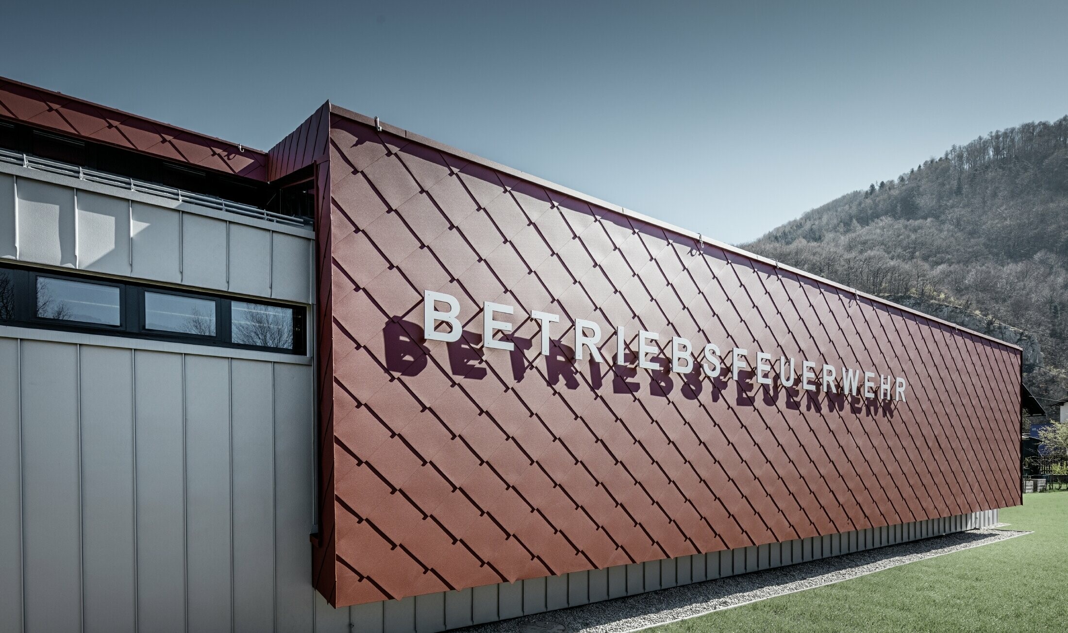 De gevel van de bedrijfsbrandweer in Marktl/Lilienfeld is bekleed met de gevellosange 44x44 in oxiderood, daarop is de belettering “Betriebsfeuerwehr” aangebracht.