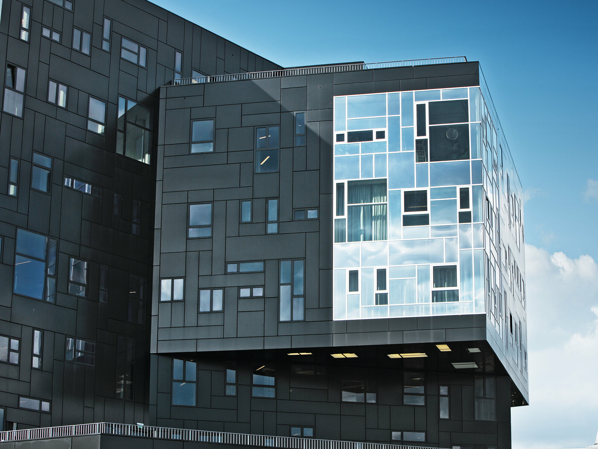 Opname van de WU Executive Academy met focus op de PREFA aluminium composietplaatgevel in diepzwart en het glanzende raamgedeelte.