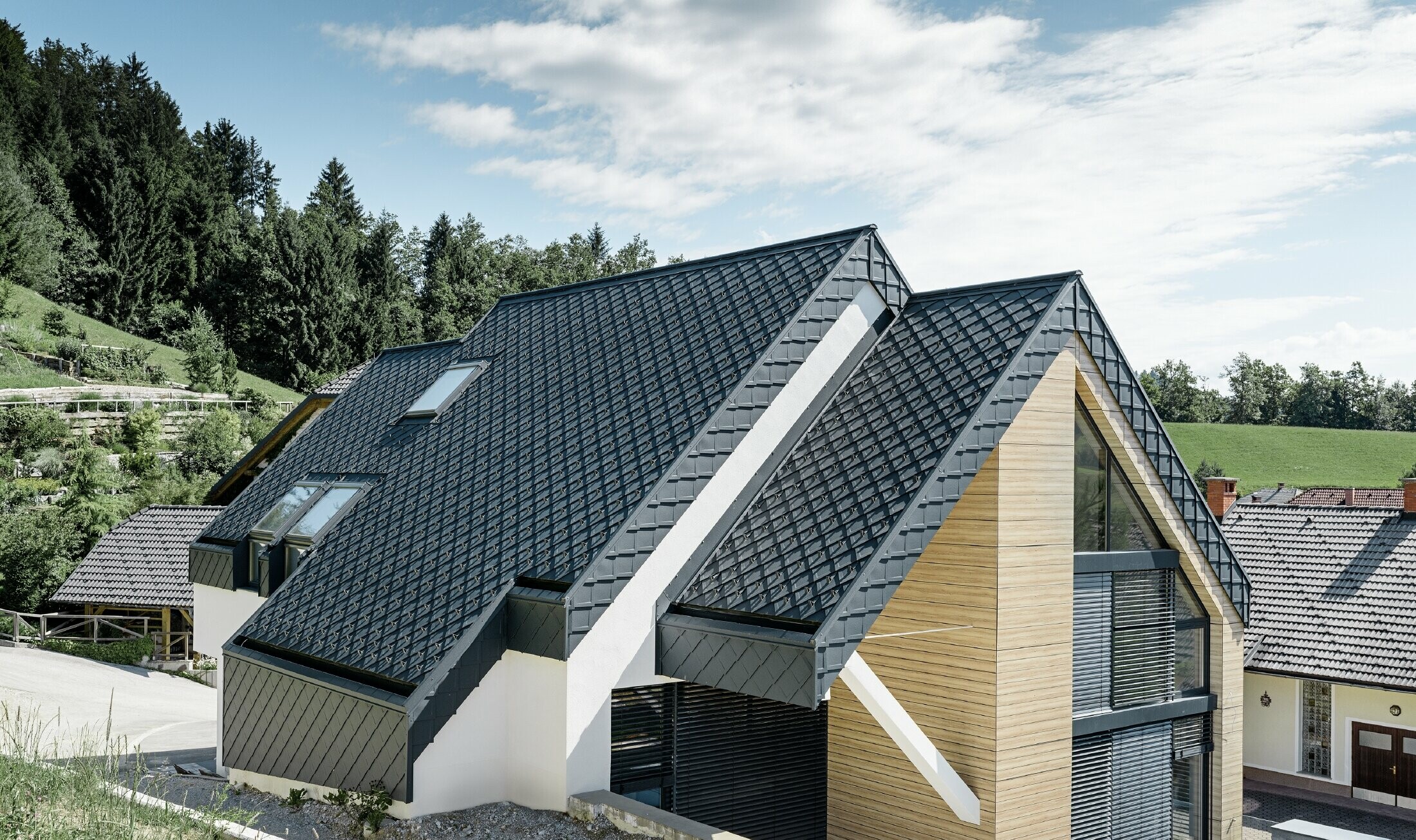 Eengezinswoning met zadeldak zonder uitstekend dak met een gevel in houtlook en een aluminium dak in antraciet
