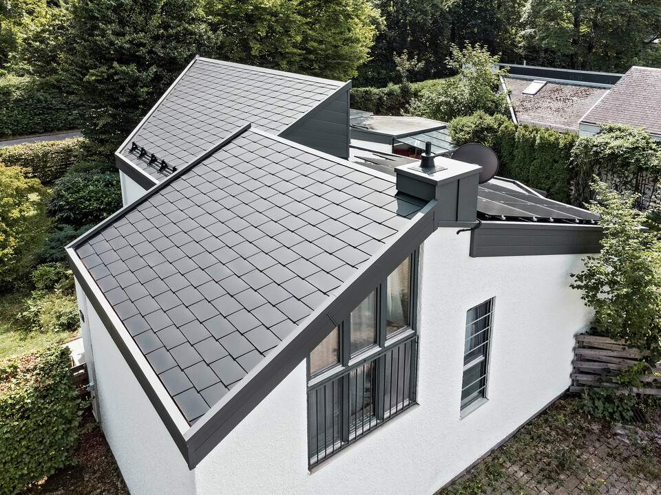 Ein Einfamilienhaus, das mit PREFA Dachschindeln DS.19 in schwarz eingedeckt wurde. Für Teile der Fassade wurden PREFA Sidings in P.10 dunkelgrau verwendet. 