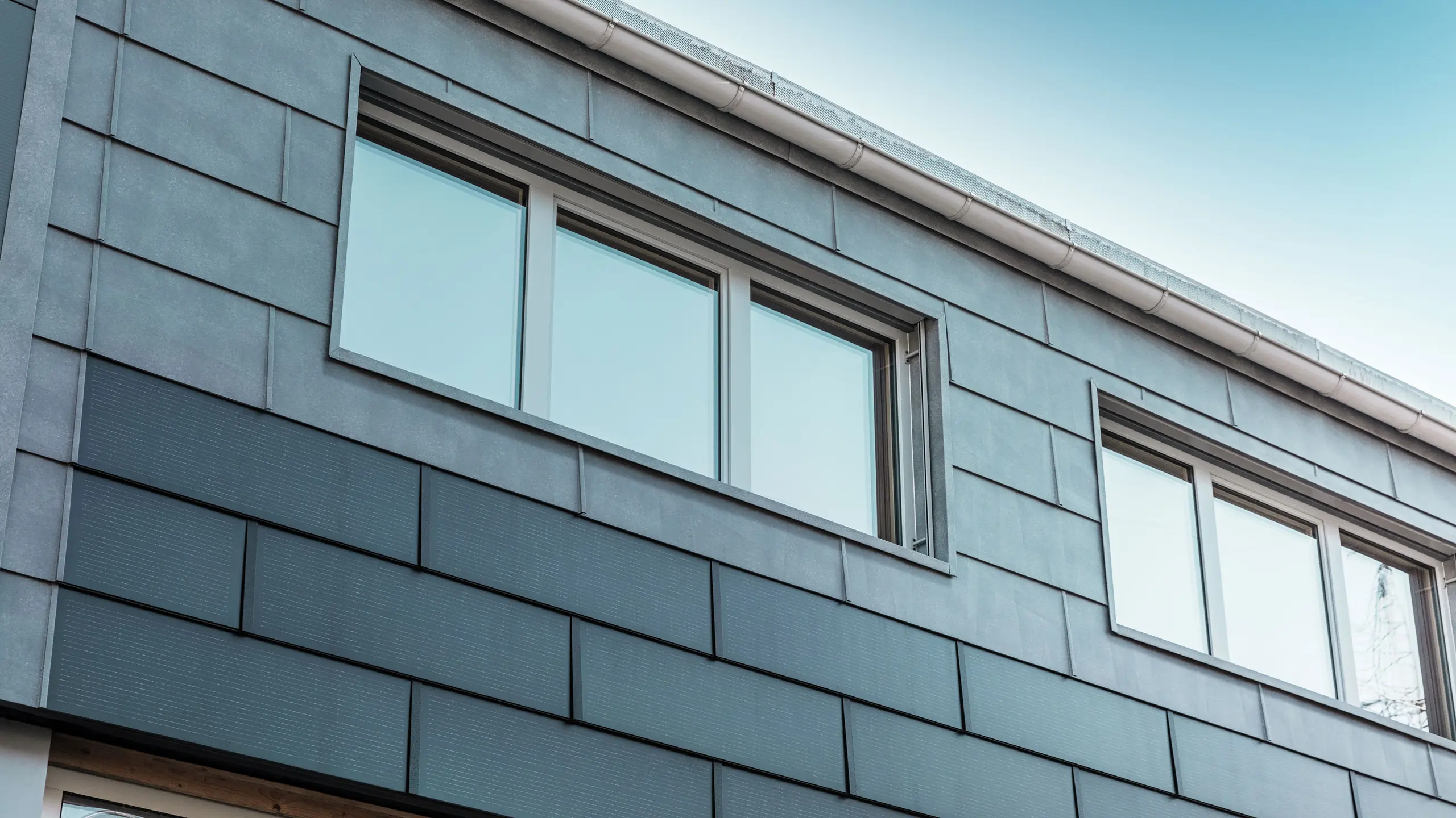 De gevel van het bedrijfsgebouw werd bekleed met innovatieve solar-dakpan, gecombineerd met gevelpaneel FX.12 van PREFA.
