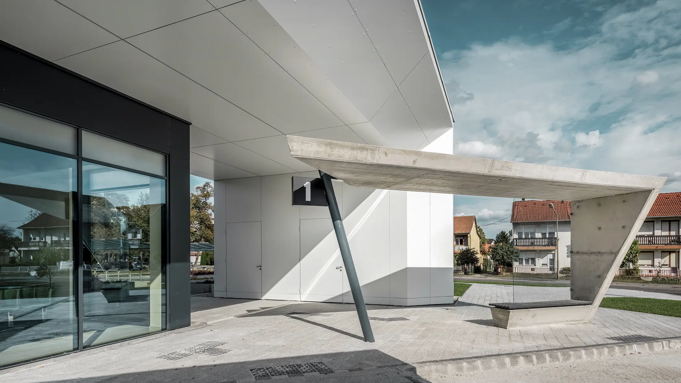 Entree van het busstation Lenti; de onderkant van de overkapping is bekleed met PREFABOND aluminium composietplaat van PREFA in zuiver wit, de gevelelementen bij de toegangsdeuren en etalages zijn bekleed met P.10 antraciet.