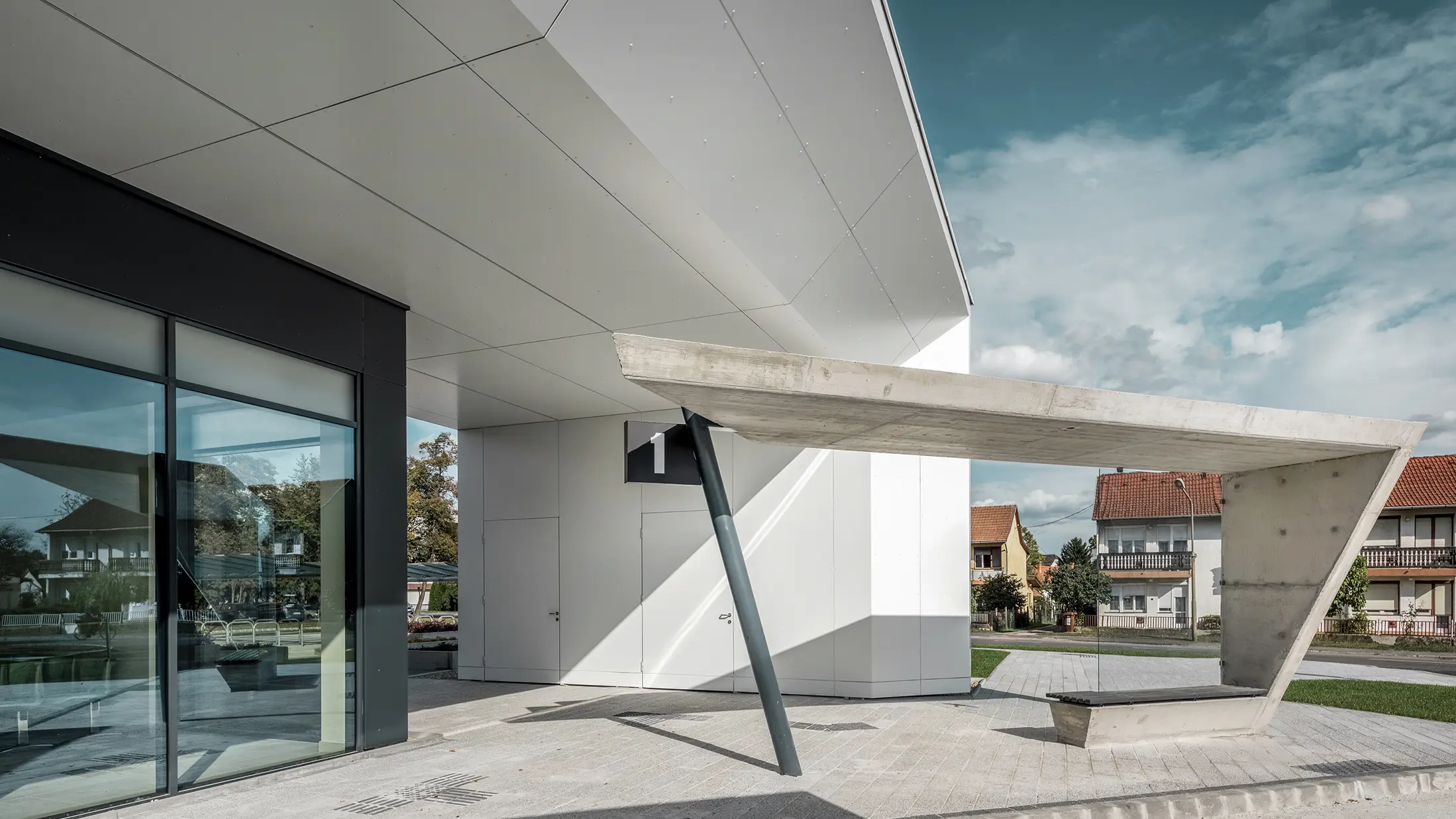Entree van het busstation Lenti; de onderkant van de overkapping is bekleed met PREFABOND aluminium composietplaat van PREFA in zuiver wit, de gevelelementen bij de toegangsdeuren en etalages zijn bekleed met P.10 antraciet.
