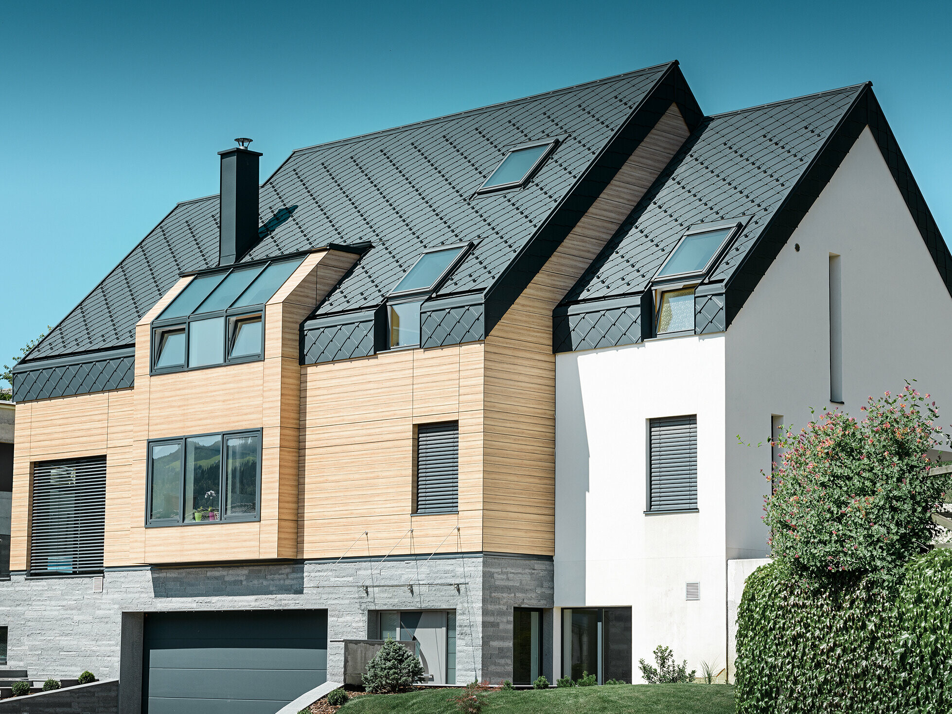 Moderne nieuwbouw, waarbij de dakbedekking over de bovenkant van de gevel doorloopt. Als dakbedekking werd de aluminium daklosange in antraciet gebruikt
