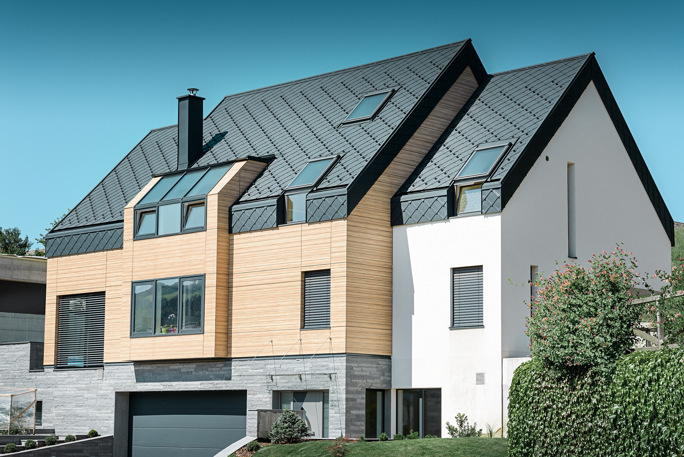 Moderne nieuwbouw, waarbij de dakbedekking over de bovenkant van de gevel doorloopt. Als dakbedekking werd de aluminium daklosange in antraciet gebruikt