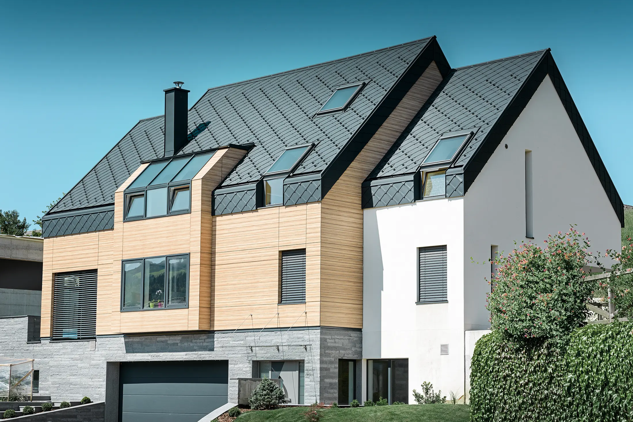 Moderne nieuwbouw, waarbij de dakbedekking over de bovenkant van de gevel doorloopt. Als dakbedekking werd de aluminium daklosange in antraciet gebruikt