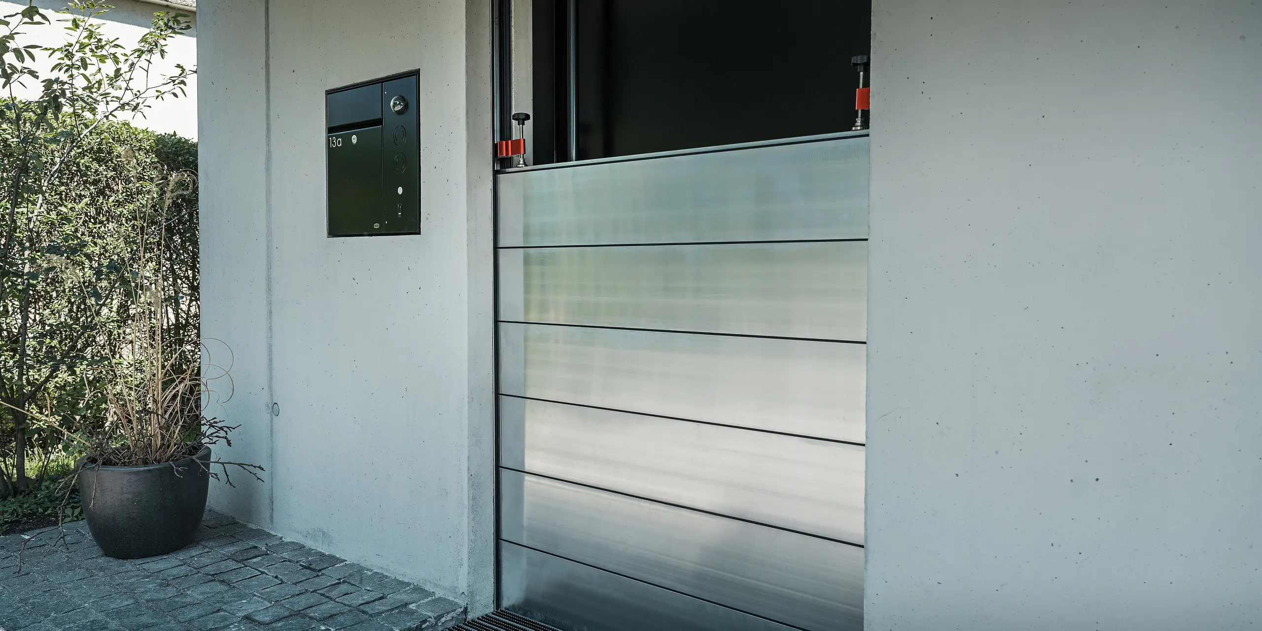 Komplettmontage des PREFA Hochwasserschutzes an der Eingangstüre eines Einfamilienhauses in Lustenau. Die formschöne Integration der Aluminiumprofile schützt das Gebäude im Ernstfall vor Hochwasser und sorgt für eine ansprechende Optik.