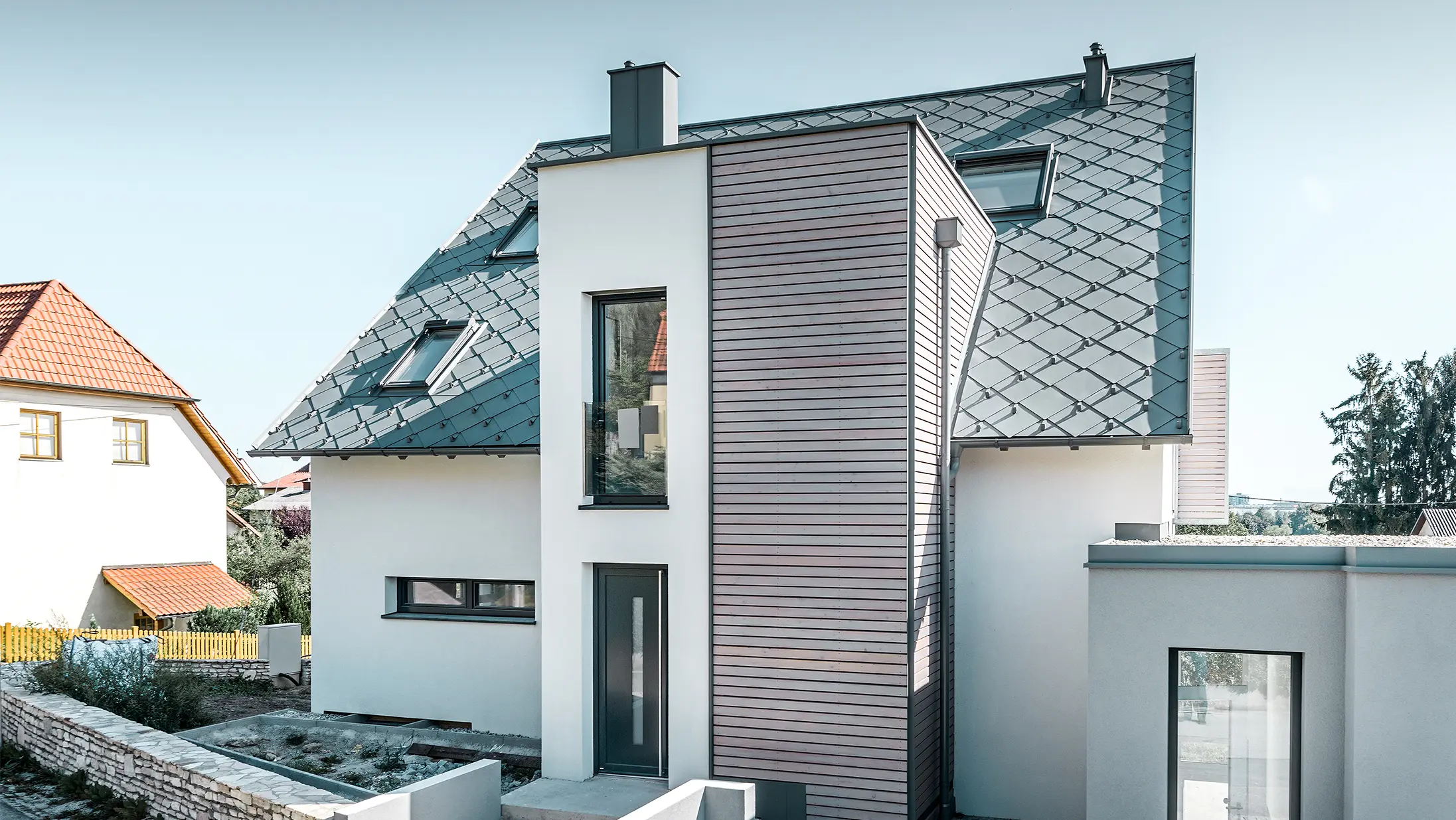 De eengezinswoning met zadeldak in leodonding werd rondom gerenoveerd. Het dakvlak werd opnieuw gedekt met de PREFA daklosange 44×44 in lichtgrijs inclusief sneeuwstoppers. De goot is de hanggoot van PREFA, eveneens in lichtgrijs. 
