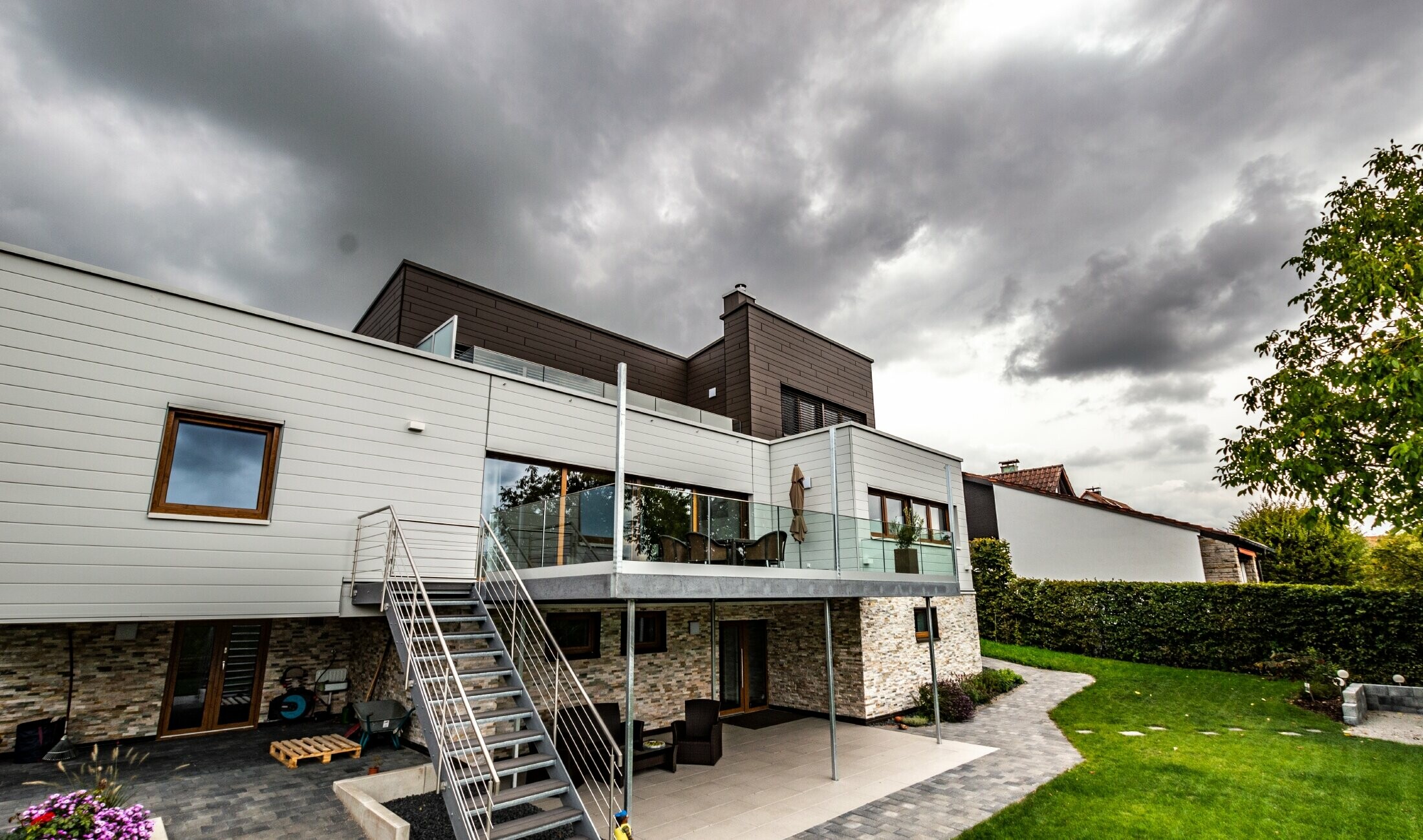 Woonhuis met plat dak en witte en bruine gevel met PREFA sidings horizontaal gemonteerd.