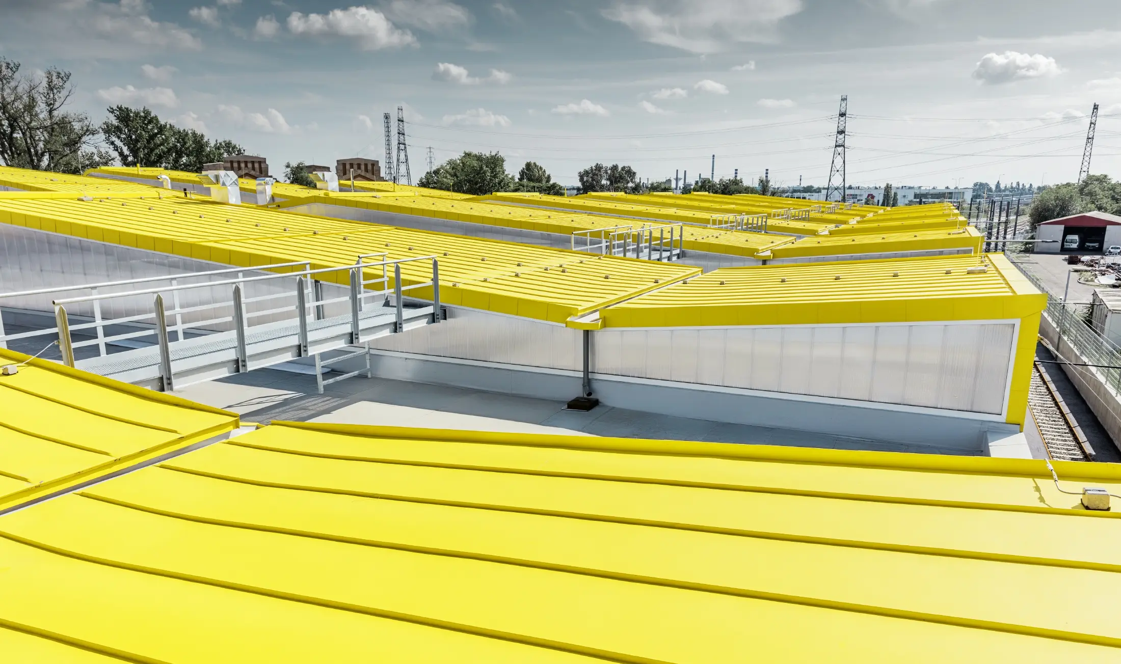 Detailbeeld van het gele dakvlak van de nieuwe remise in Boedapest met staand felsdak van PREFA;