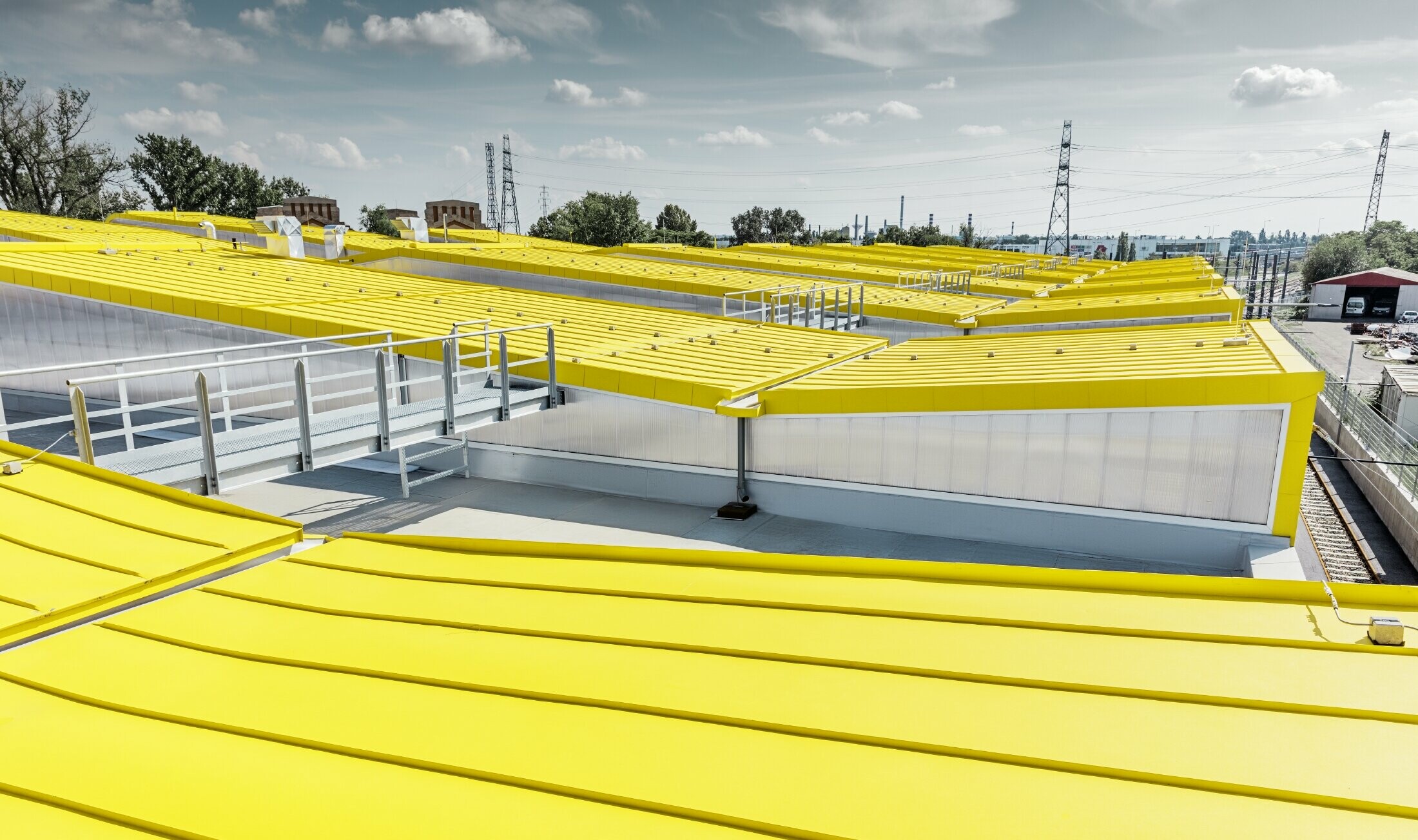 Detailbeeld van het gele dakvlak van de nieuwe remise in Boedapest met staand felsdak van PREFA;