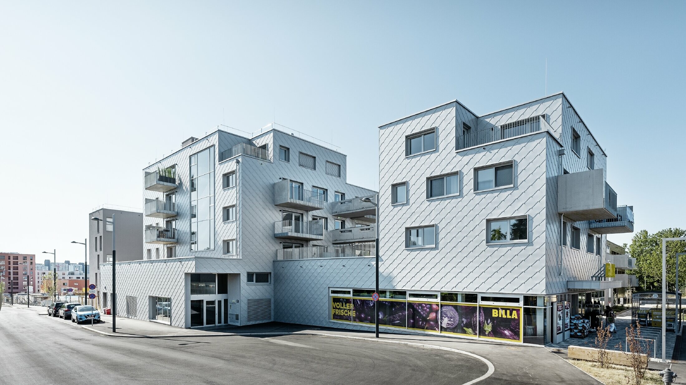 Woongebouwen met plat dak en wandlosangegevel met de PREFA gevellosange 44 × 44 in zilvermetallic