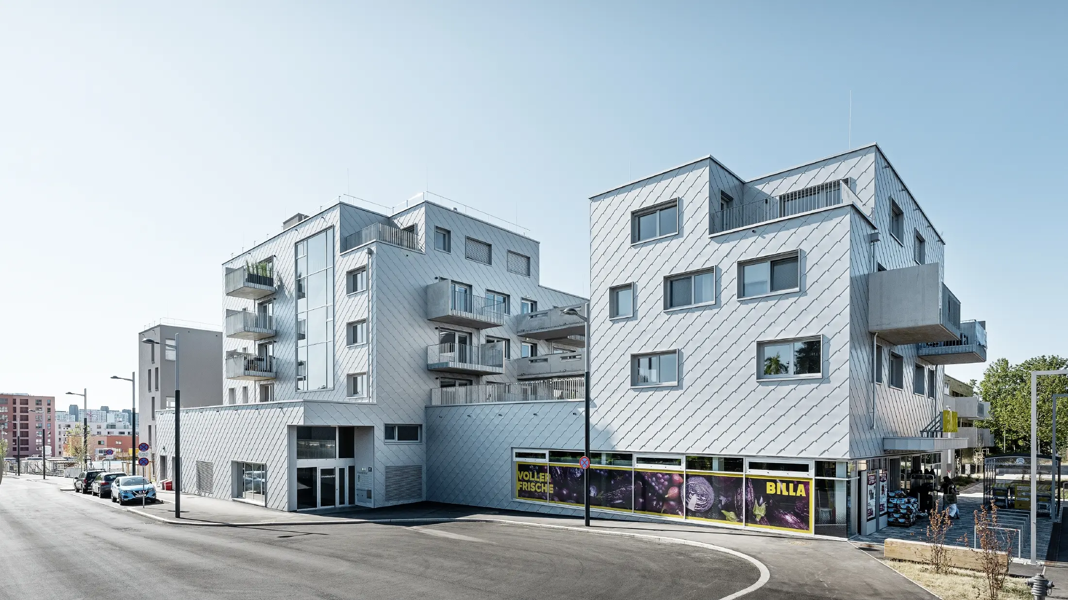 Woongebouwen met plat dak en wandlosangegevel met de PREFA gevellosange 44 × 44 in zilvermetallic